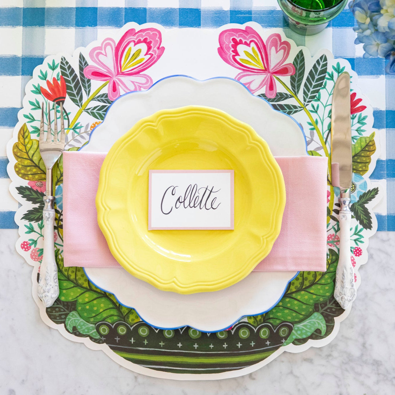 Pink Frame Place Card with &quot;Collette&quot; written on it, centered on dinner plates, on a spring themed place setting.