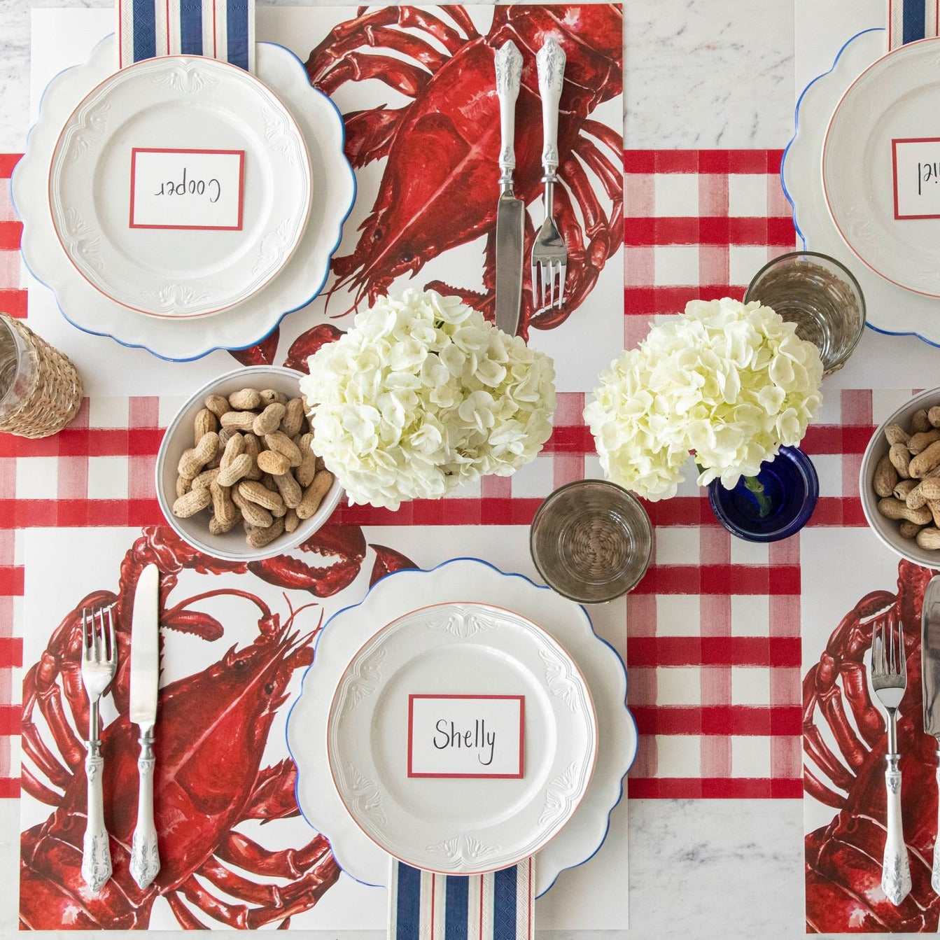The Maine Lobster Placemat used in a nautical themed table setting for four, from above. 