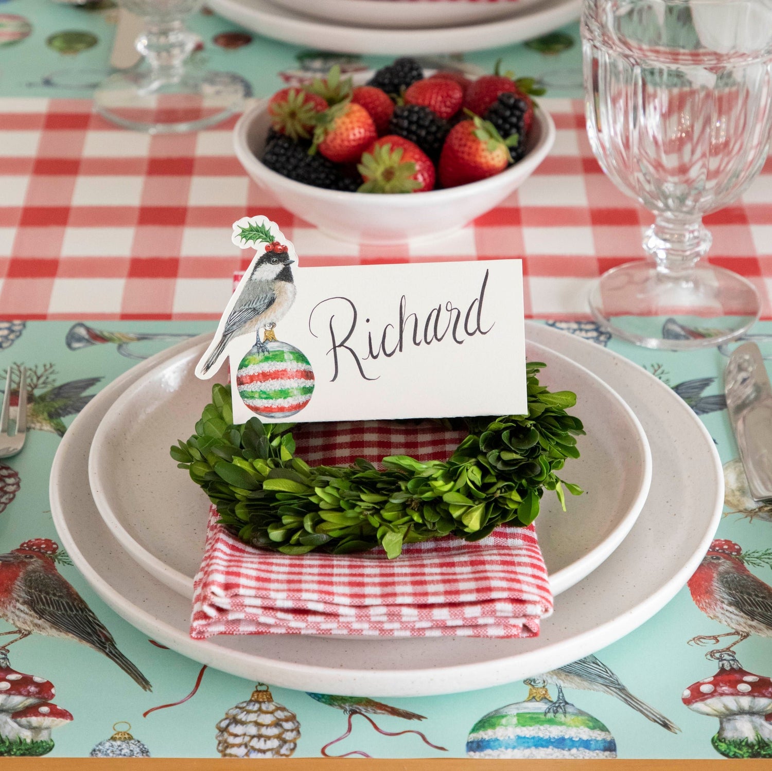 The Christmas Chickadee Place Card  with &quot;Richard&quot;  written on it, on top of a festive place setting.