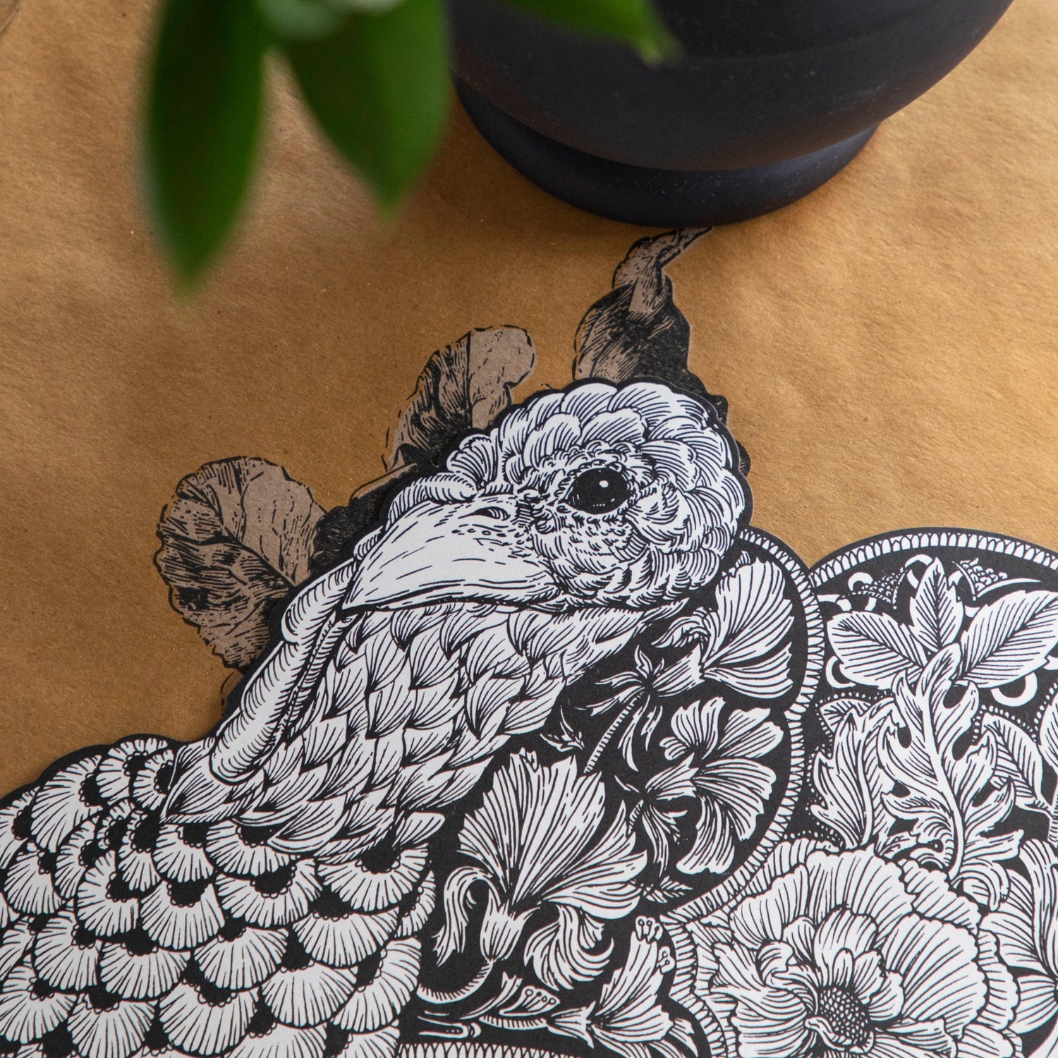A Hester &amp; Cook Die-cut Ebony Harvest Turkey Placemat, placed on a table adorned with an autumnal plant, perfect for Thanksgiving.