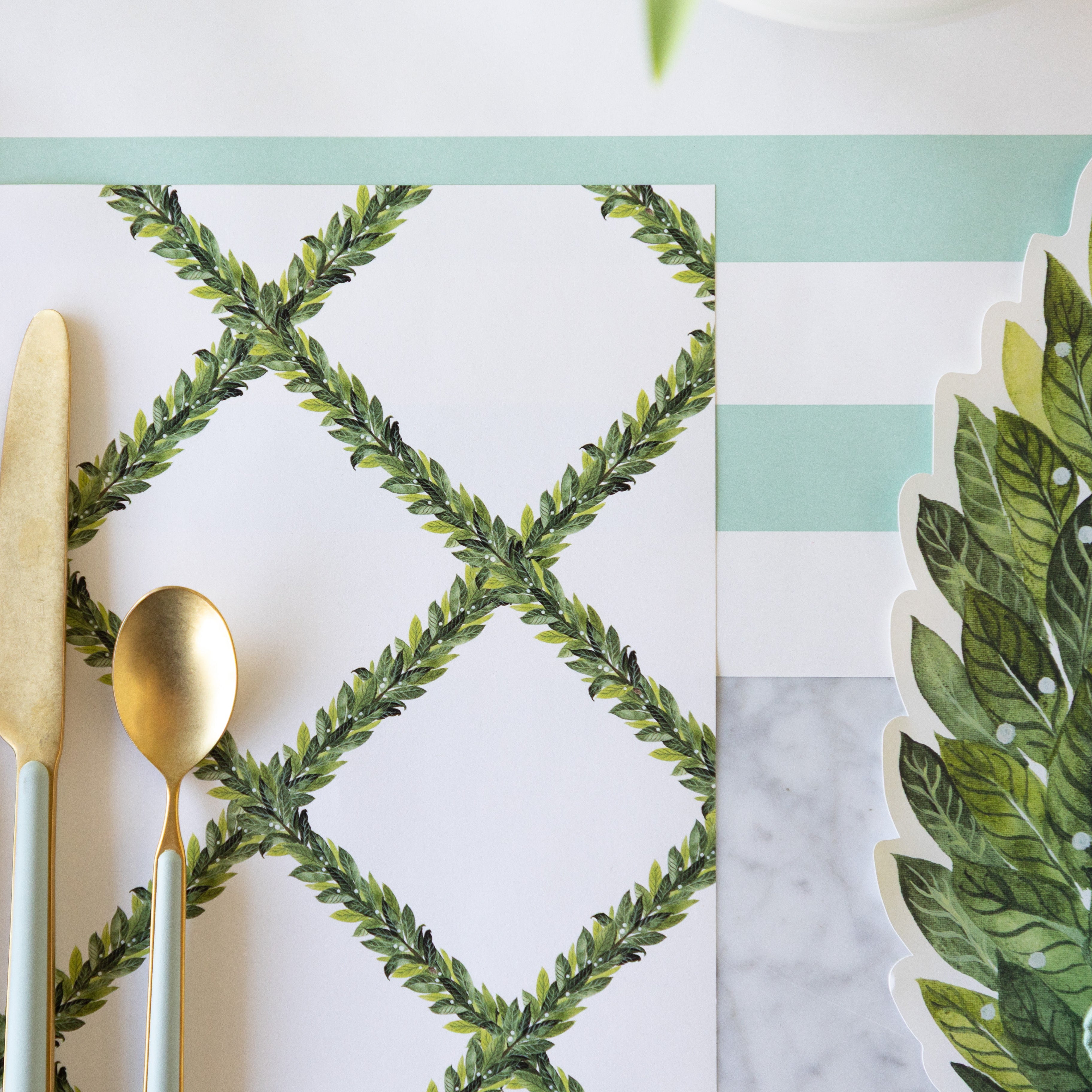 The Laurel Lattice Placemat beside the Die-cut Laurel Wreath Placemat on the Seafoam Classic Stripe Runner.