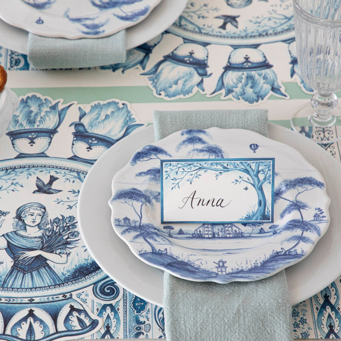 A table setting with blue and white Juliska Country Estate Delft Blue Dinnerware dinner plates and napkins.