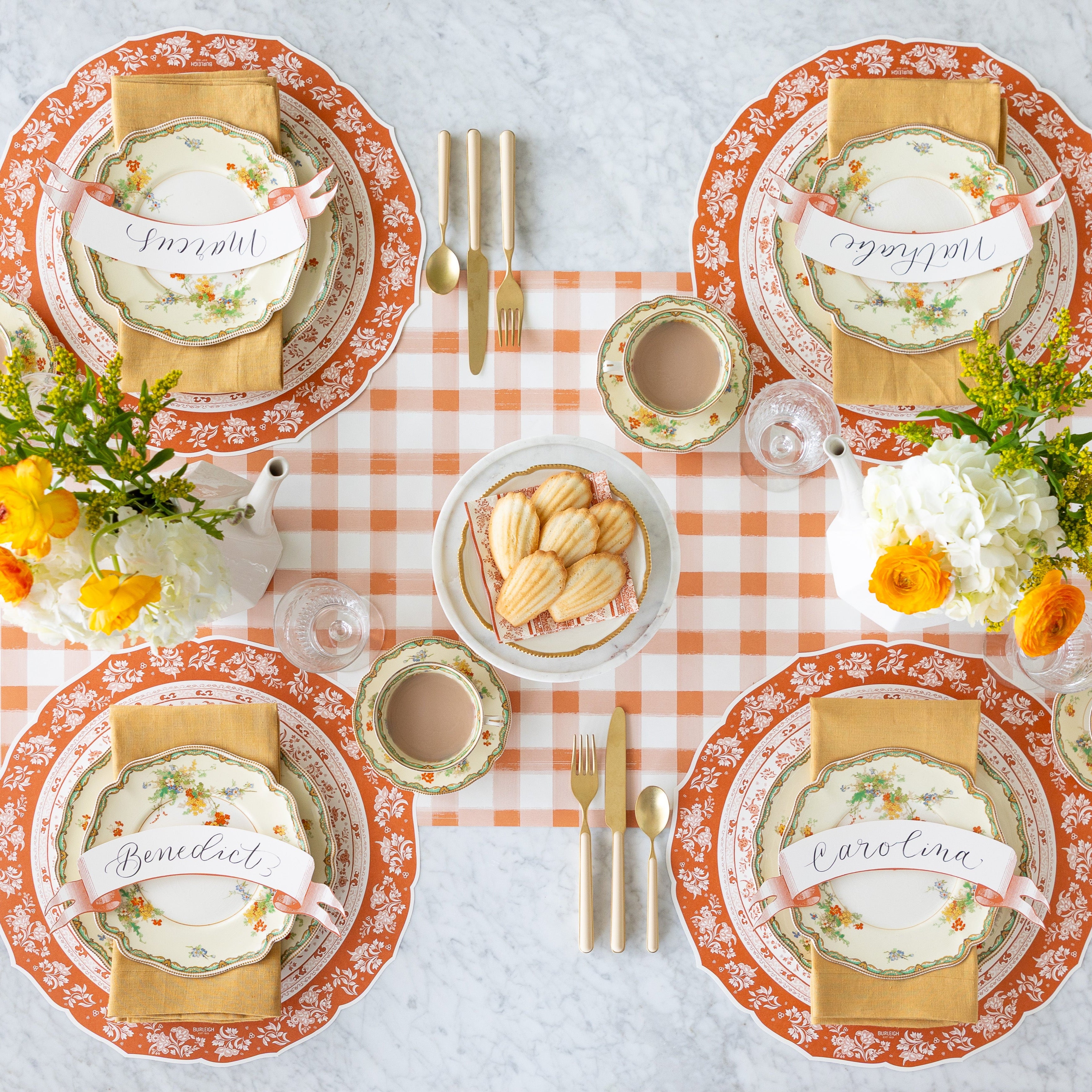 A fall table setting with floral centerpieces and Madeline&