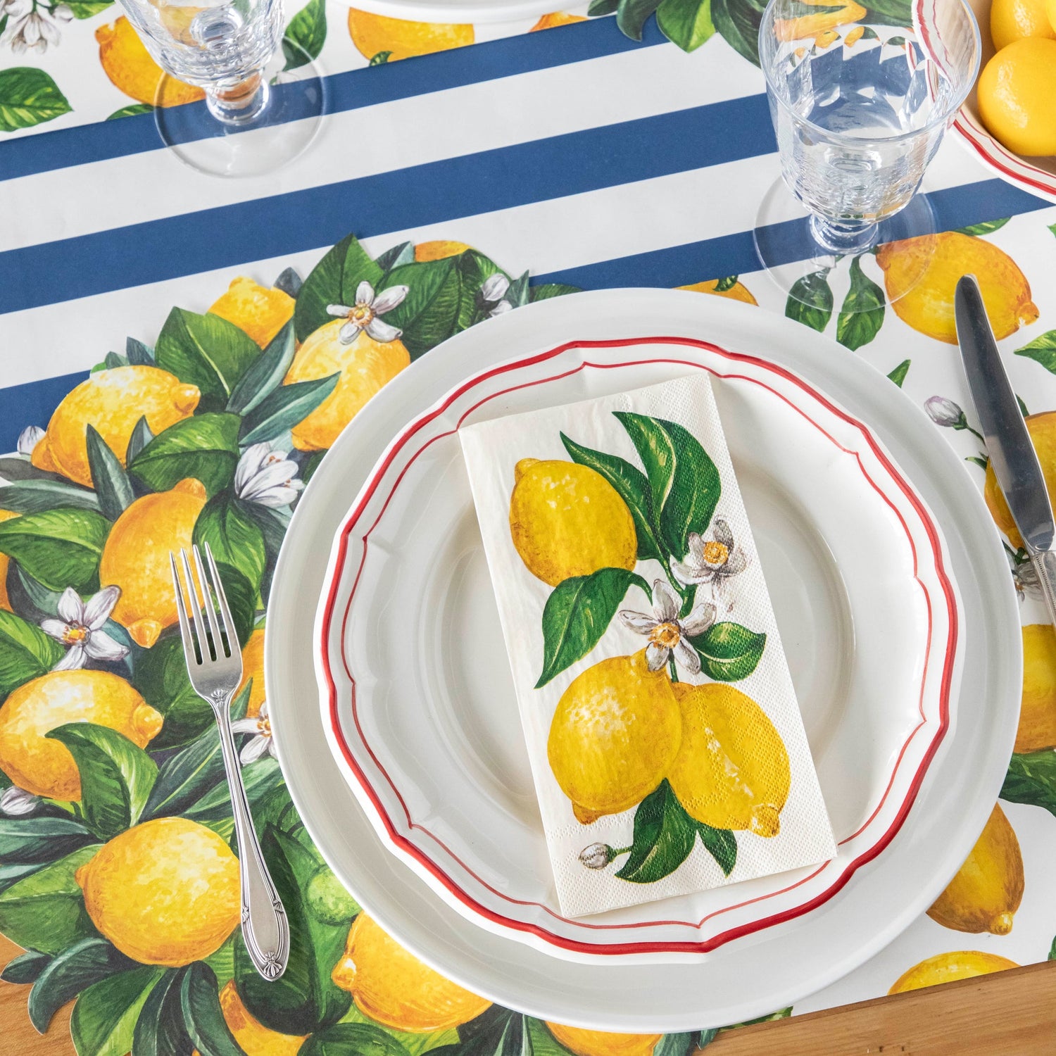 Table setting with a Lemon Wreath Placemat, white plates, Lemons Guest Napkin, and a vintage fork on the Navy Classic Stripe Runner.