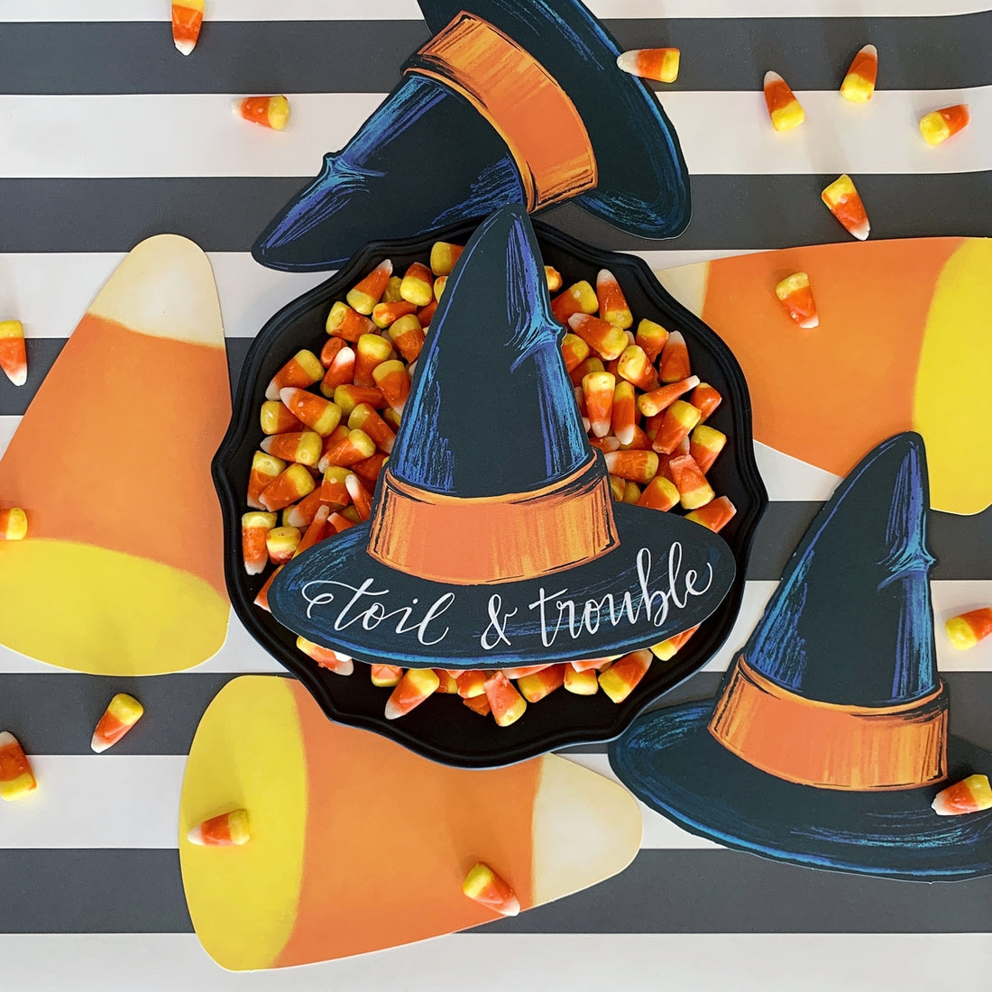 A Halloween candy table featuring Candy Corn Table Accents scattered on the table, from above.