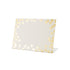 A white, rectangular freestanding place card featuring scattered gold foil dots adorning the edges.