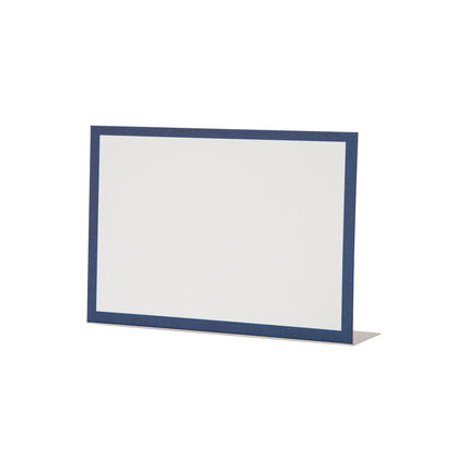 A free-standing, rectangular white table card with a simple navy blue frame around the edges.