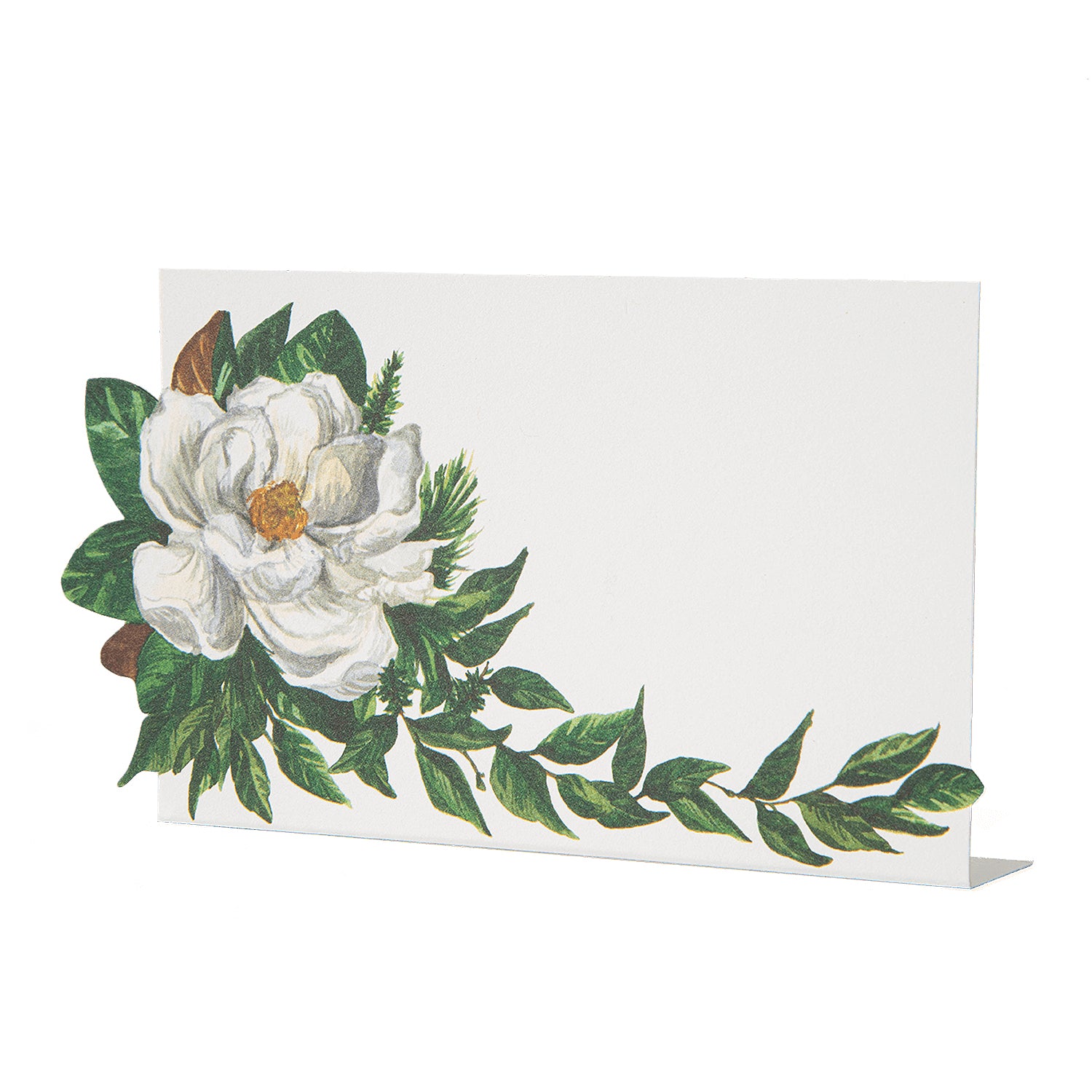 A white, rectangular freestanding place card featuring artwork of a white magnolia bloom adorning the left side of the card, with deep green foliage around the flower and trailing along the bottom edge of the card.