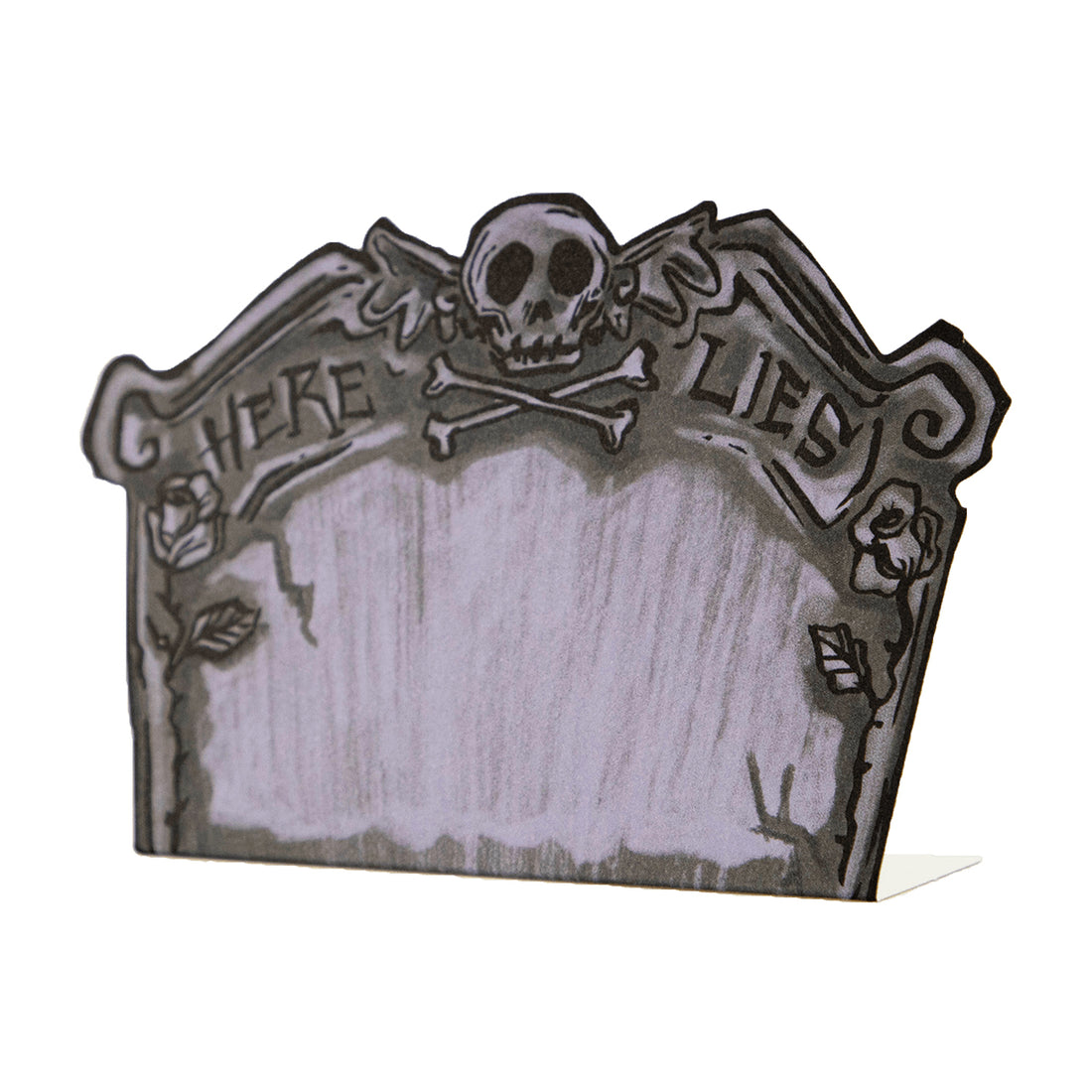 A die-cut freestanding place card depicting a spooky illustrated tombstone in gray with black linework, reading "HERE LIES" across the top with a skull and crossbones, and a blank gray area in the middle for personalization.