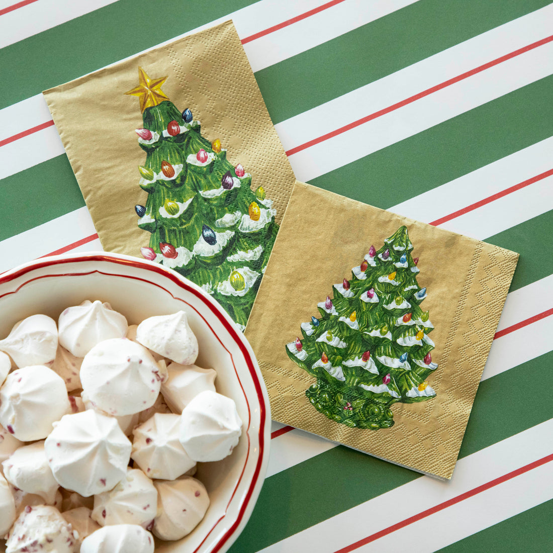 Two Vintage Christmas Tree Napkins, one Cocktail and one Guest, tucked under a bowl of holiday treats on the Green &amp; Red Awning Stripe Runner.