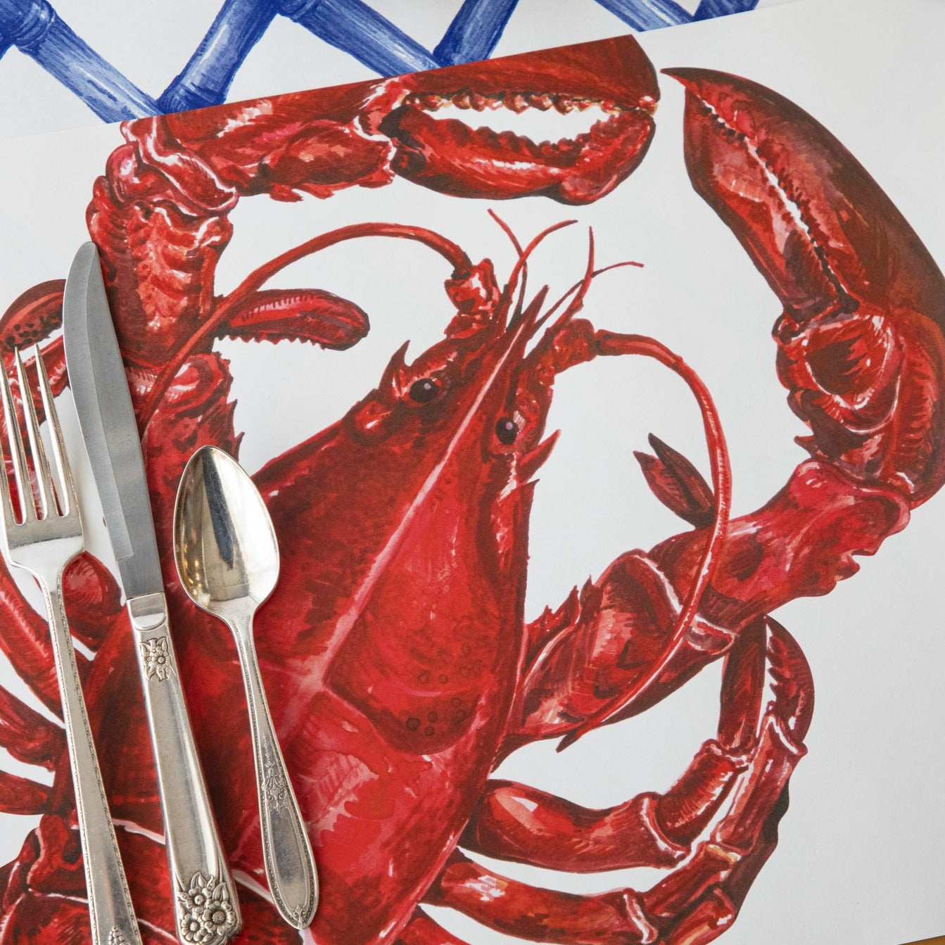 Close-up of the Maine Lobster Placemat in a place setting, showing the lobster art in detail.