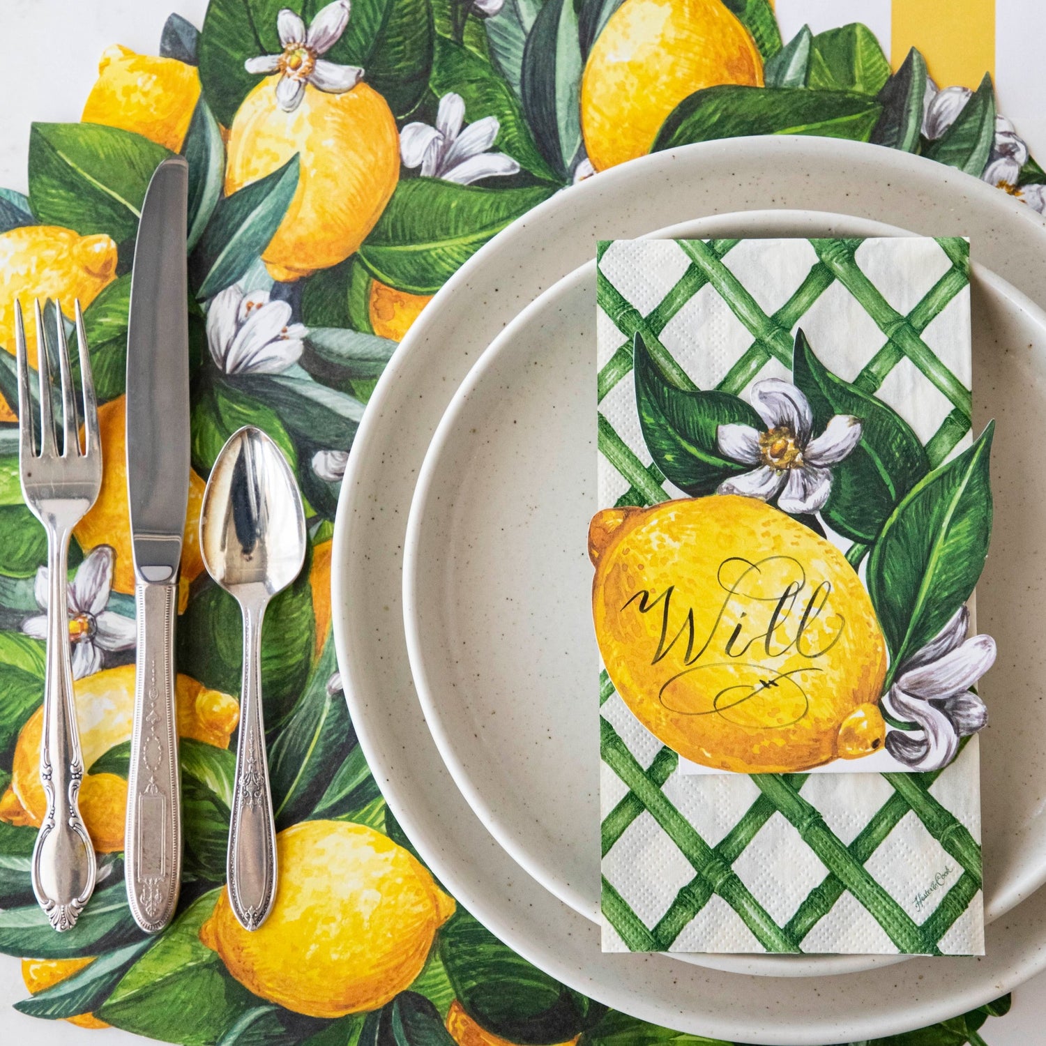 A Die-cut Lemon Wreath with leaves and flowers placed on a Hester &amp; Cook placemat.