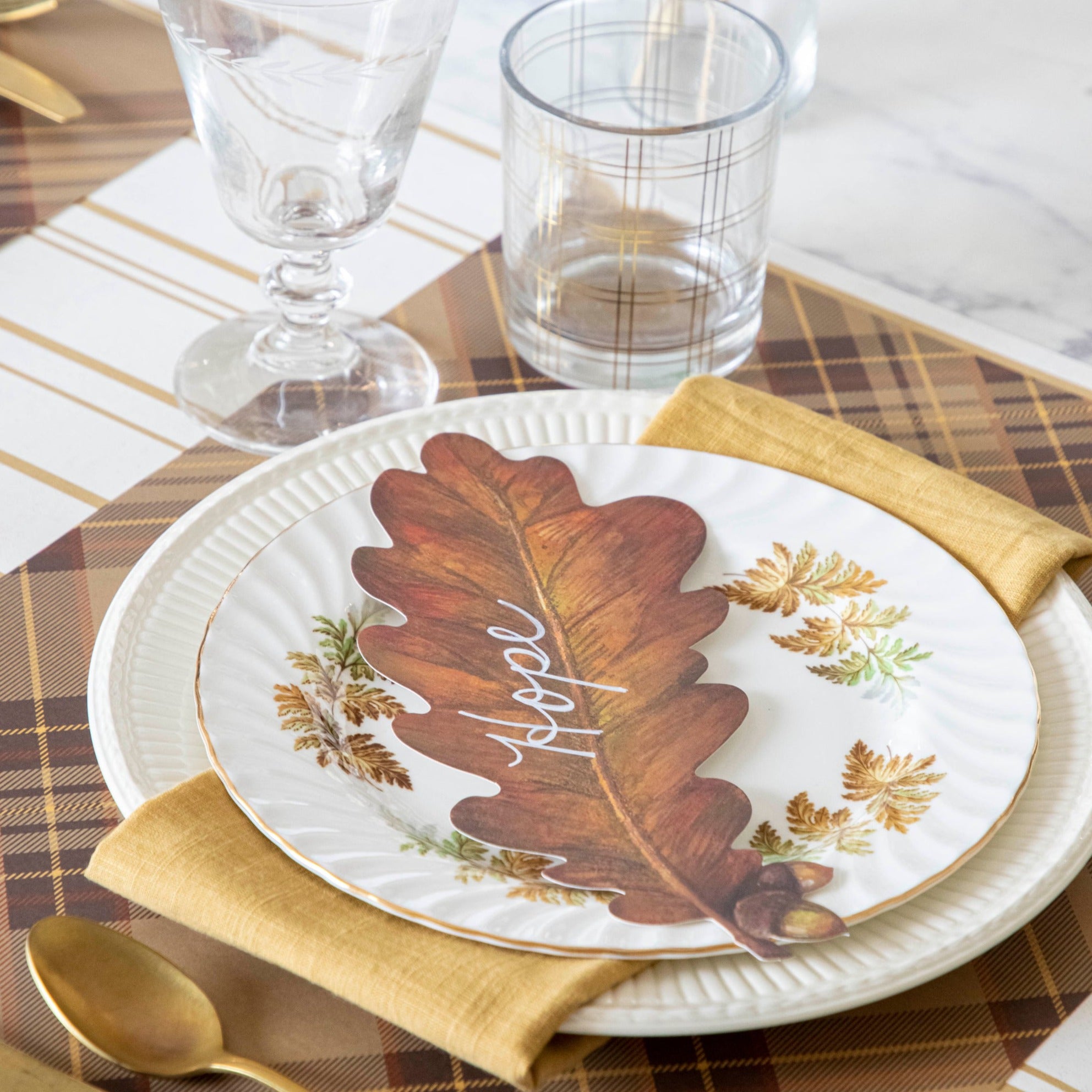An Autumn Plaid Placemat in a place setting, with a Leaf Table Accent.