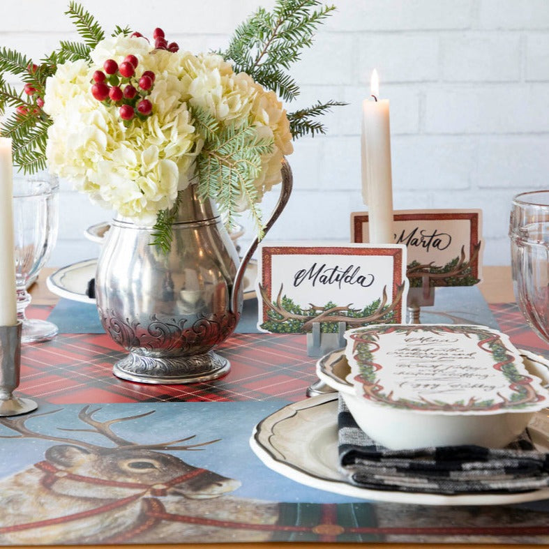 A festive winter tablescape featuring Antler Frame Place Cards held up by place card stands.