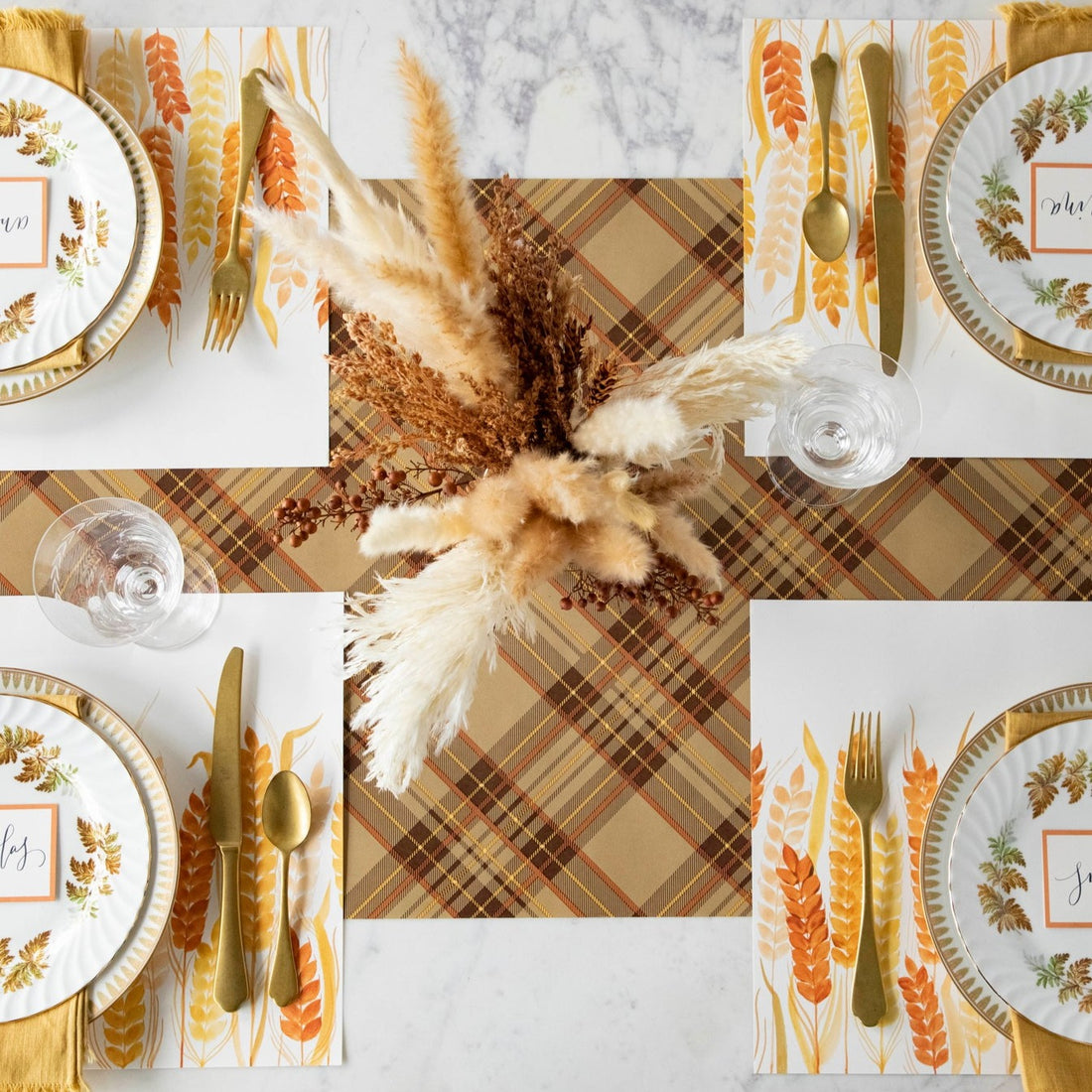 Thanksgiving table setting with the Hester &amp; Cook Autumn Plaid Runner, gold and brown plates, and silverware, featuring autumn colors.