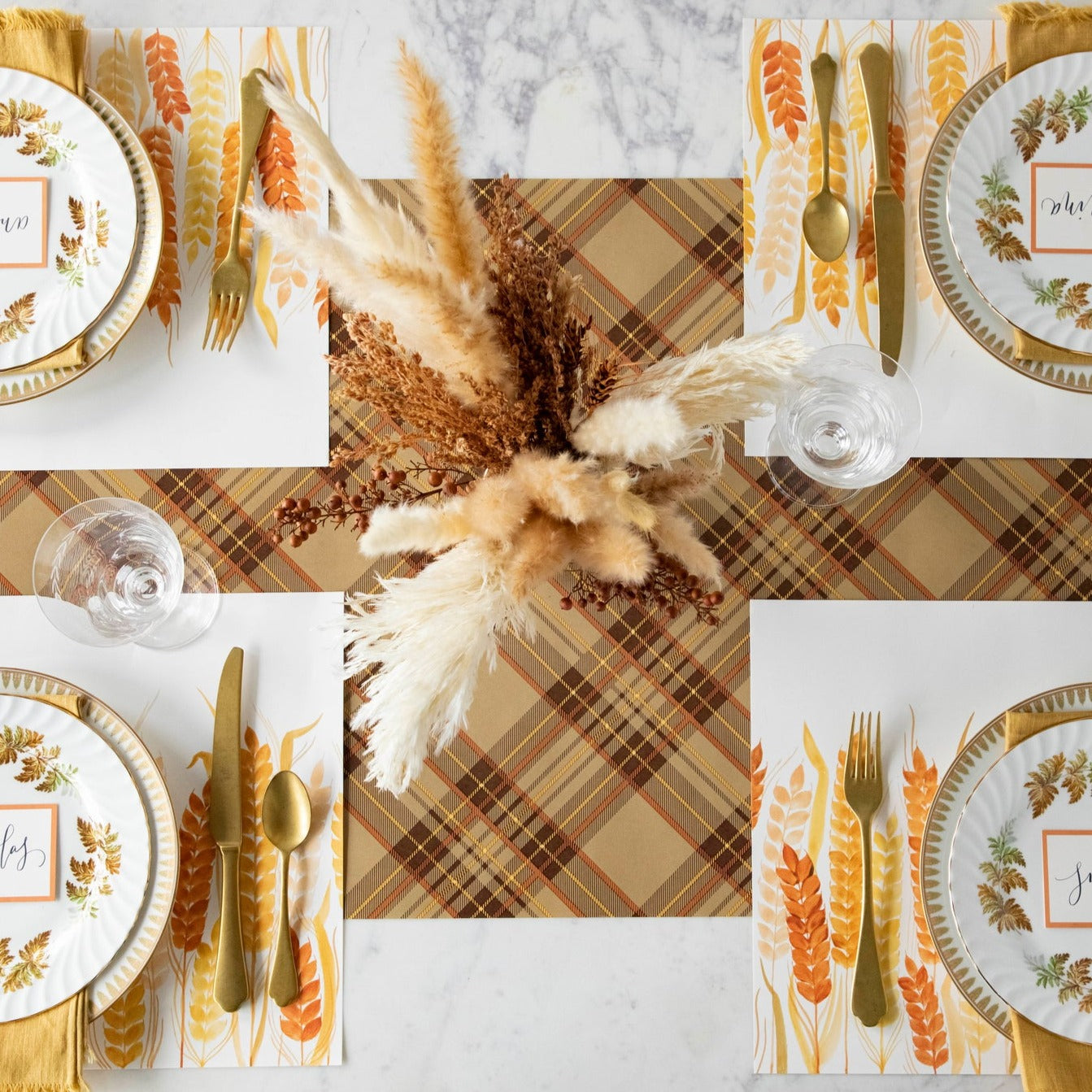 Thanksgiving table setting with the Hester &amp; Cook Autumn Plaid Runner, gold and brown plates, and silverware, featuring autumn colors.