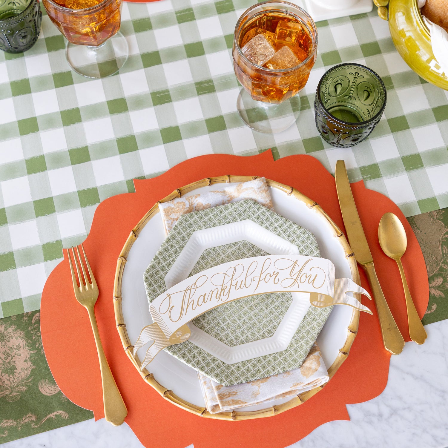 Thanksgiving table setting with orange placemats, white plates with &