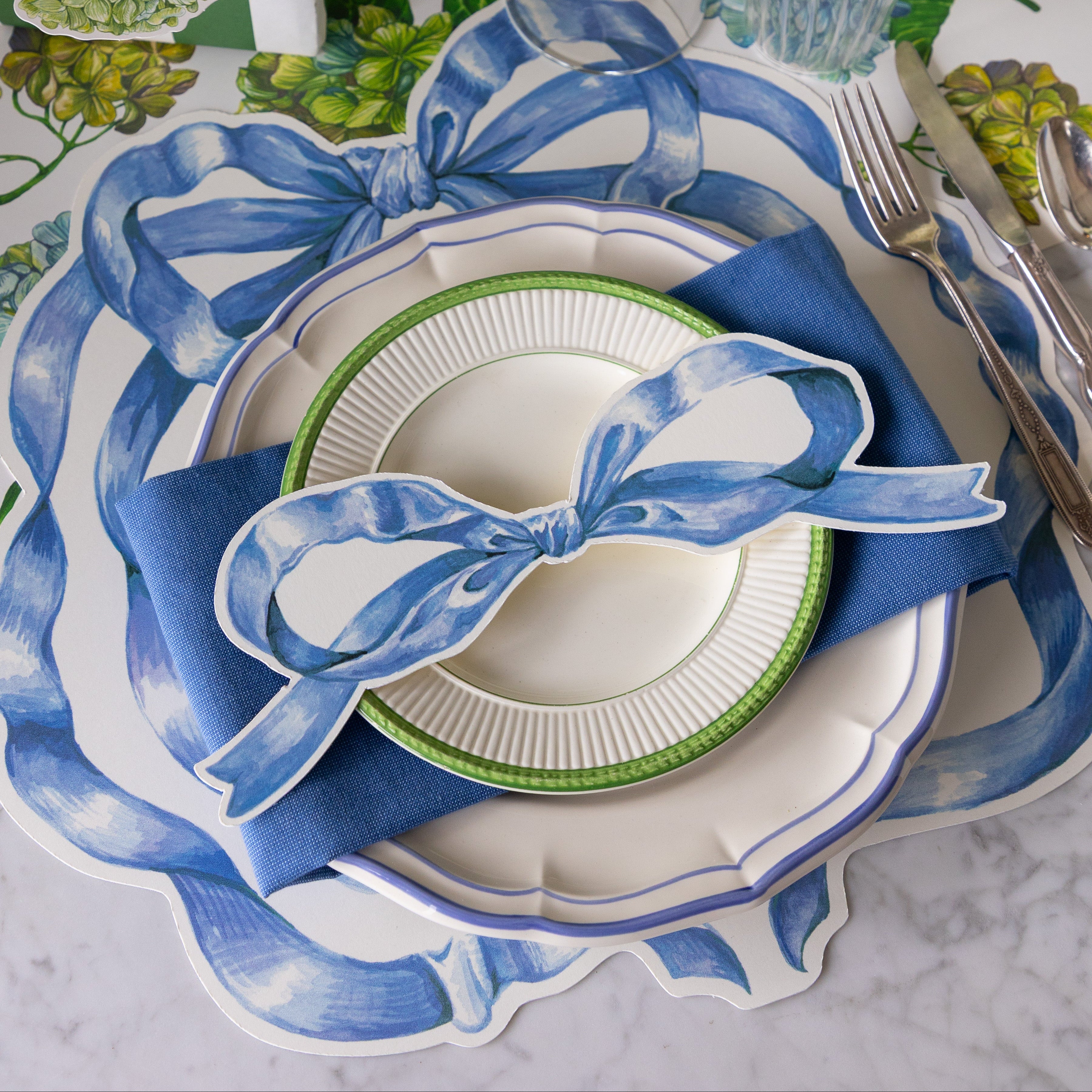 Elegant table setting with Heirloom Blue Bow Placemat, blue napkin, blue and white plates and Heirloom Blue Bow Table Accent.