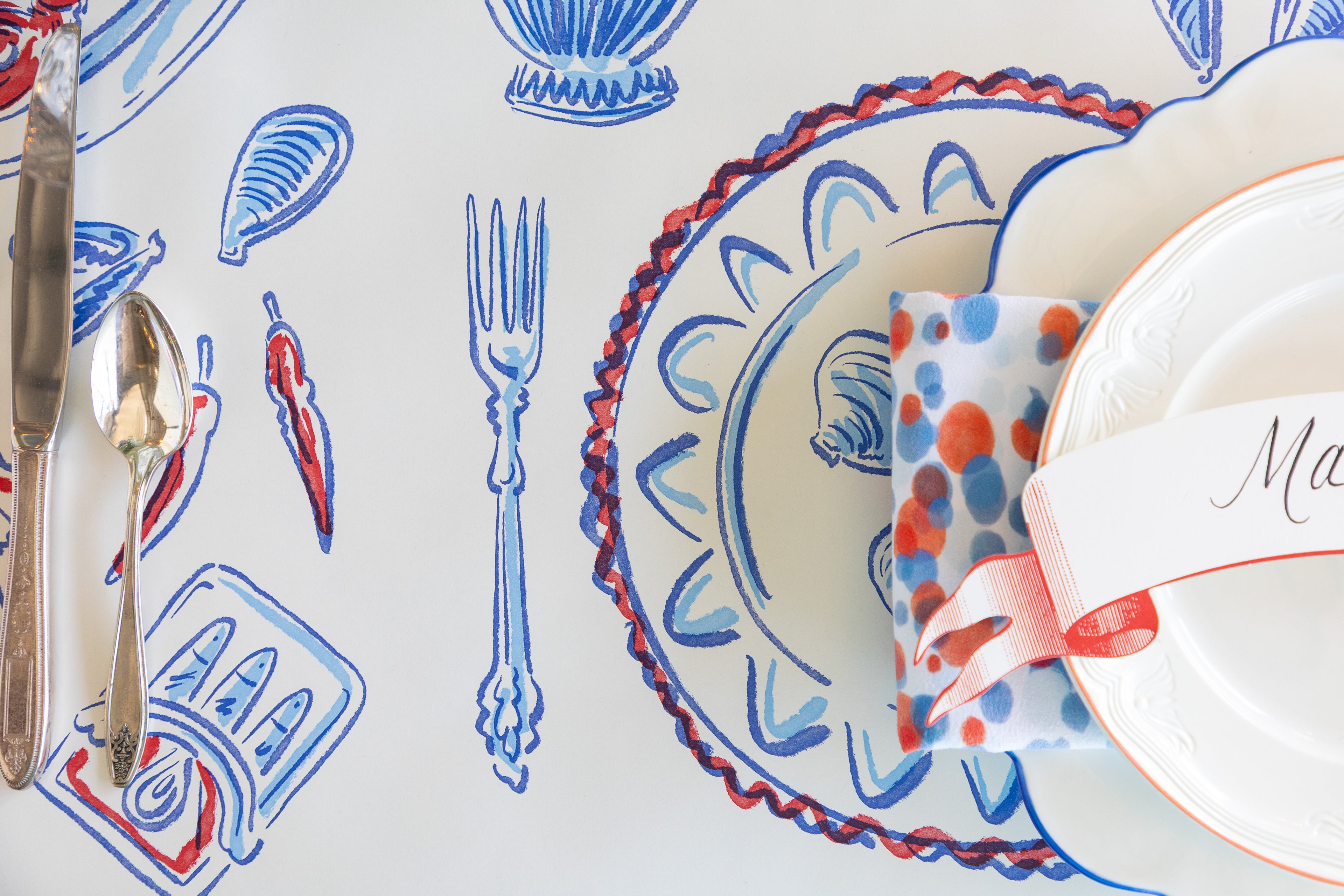 Decorative table setting with blue and red patterns on a white background.