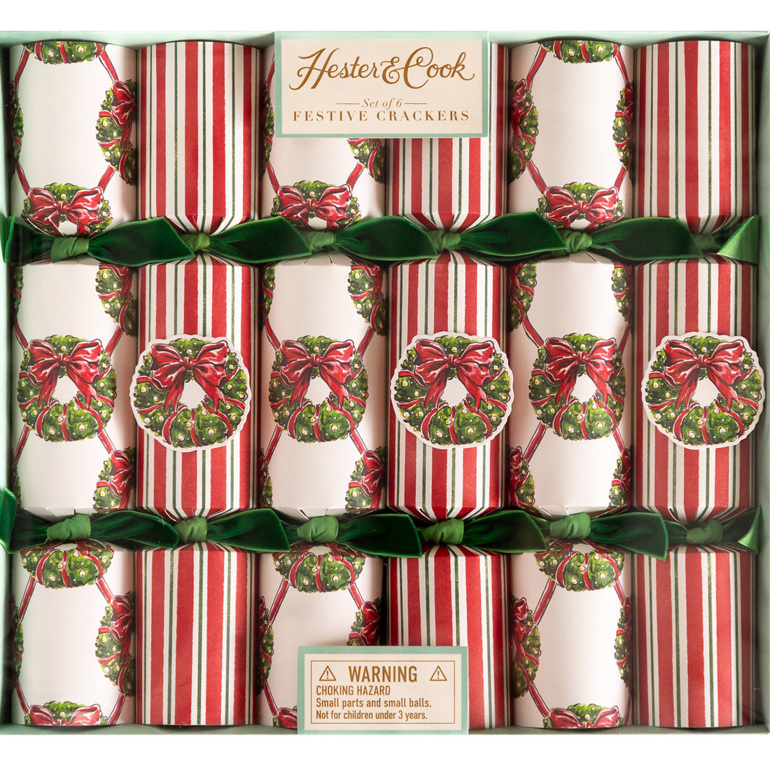 A box of Hester &amp; Cook Holiday Wreath Crackers; some decorated with a wreath lattice pattern and others a red and green stripe pattern––all tied with green velvet ribbons.