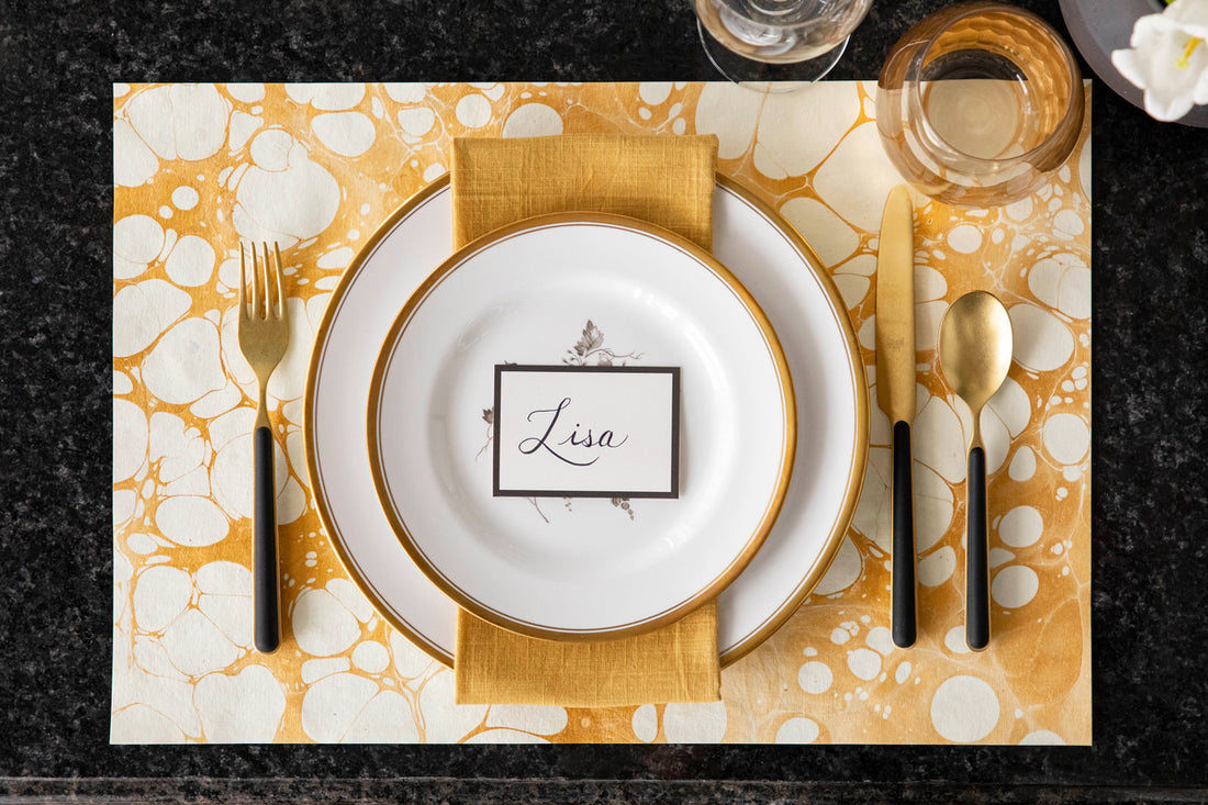 The Gold Stone Marbled Placemat under an elegant place setting, from above.
