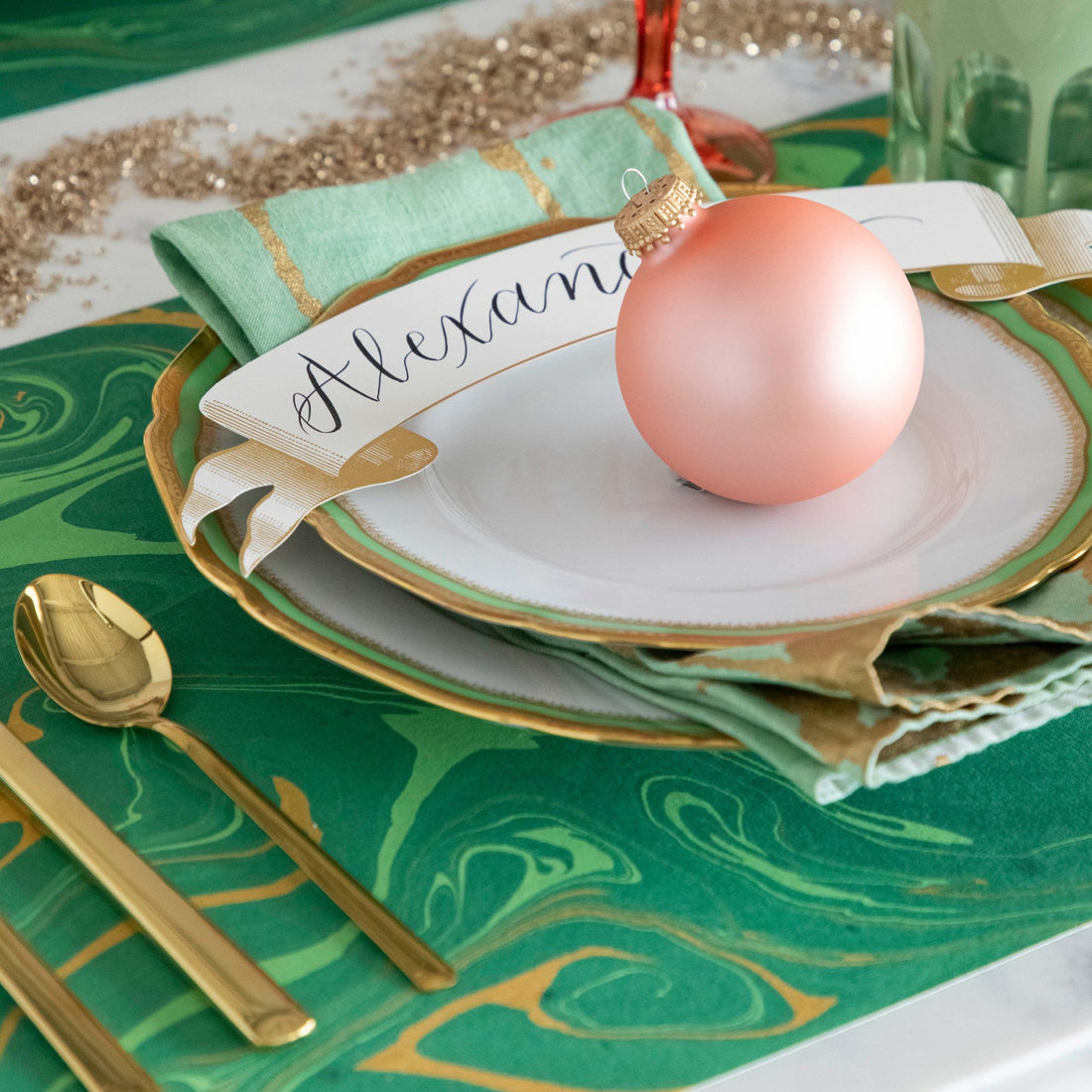 Close-up of the Green &amp; Gold Vein Marbled Placemat under a festive holiday-themed place setting.