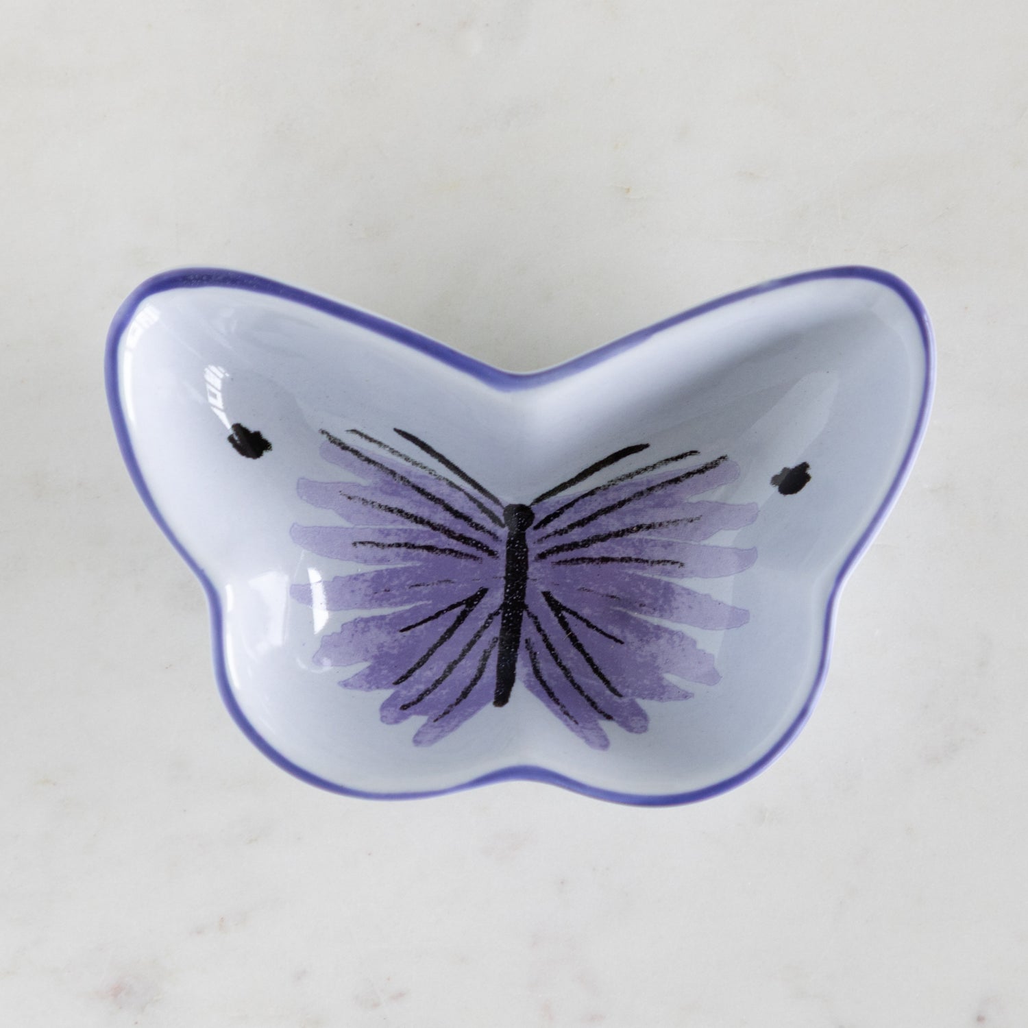 Butterfly-shaped dish with purple butterfly design on a light background.