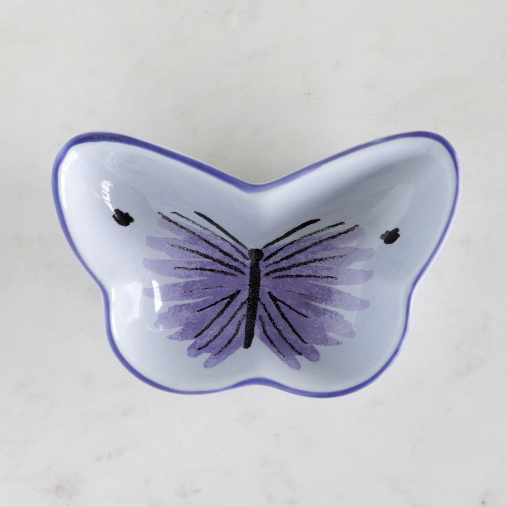 Butterfly-shaped dish with purple butterfly design on a light background.