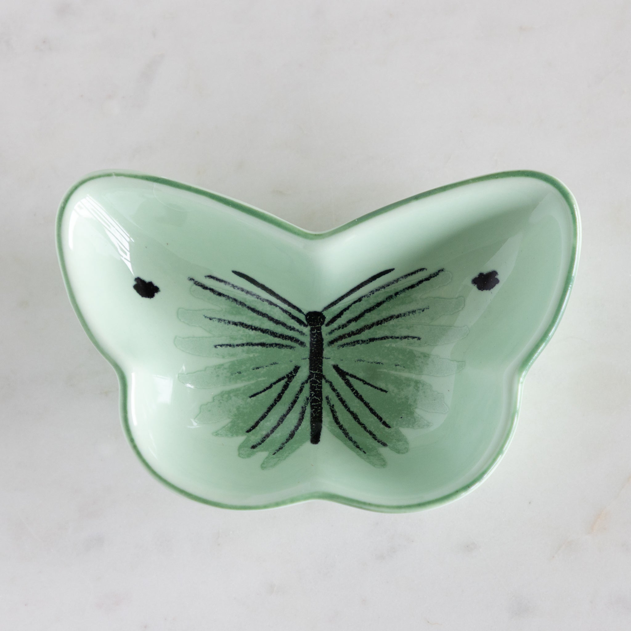 Green butterfly-shaped dish on a light gray background.