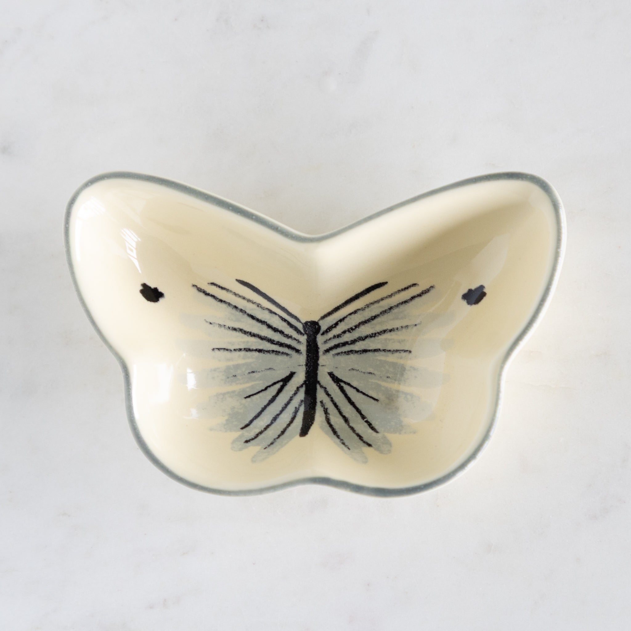 Butterfly-shaped ceramic dish on a white background.