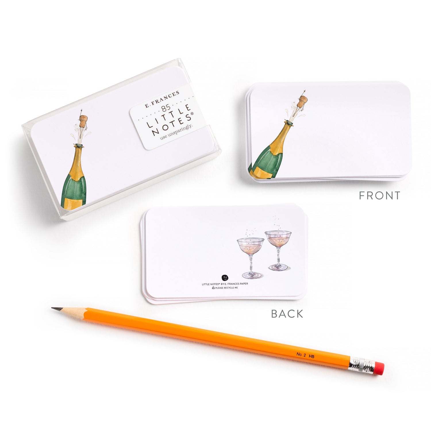 Note cards with champagne bottle and glass illustrations, an orange pencil, and a white box on a white background.