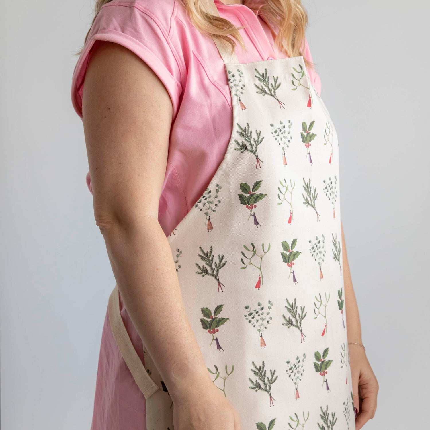 A woman wearing the Laura Stoddart Christmas Apron.