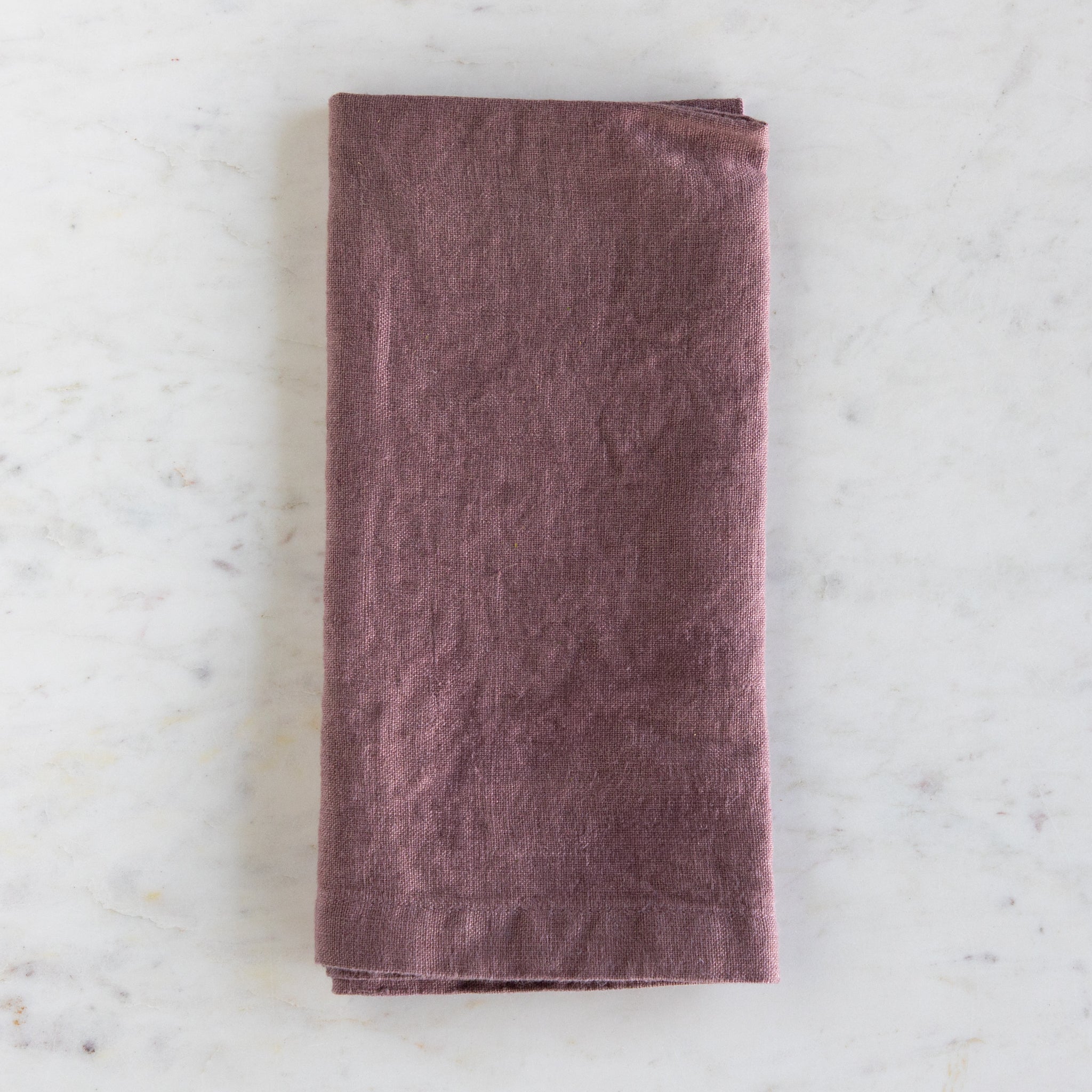 Folded purple towel on a marble surface.