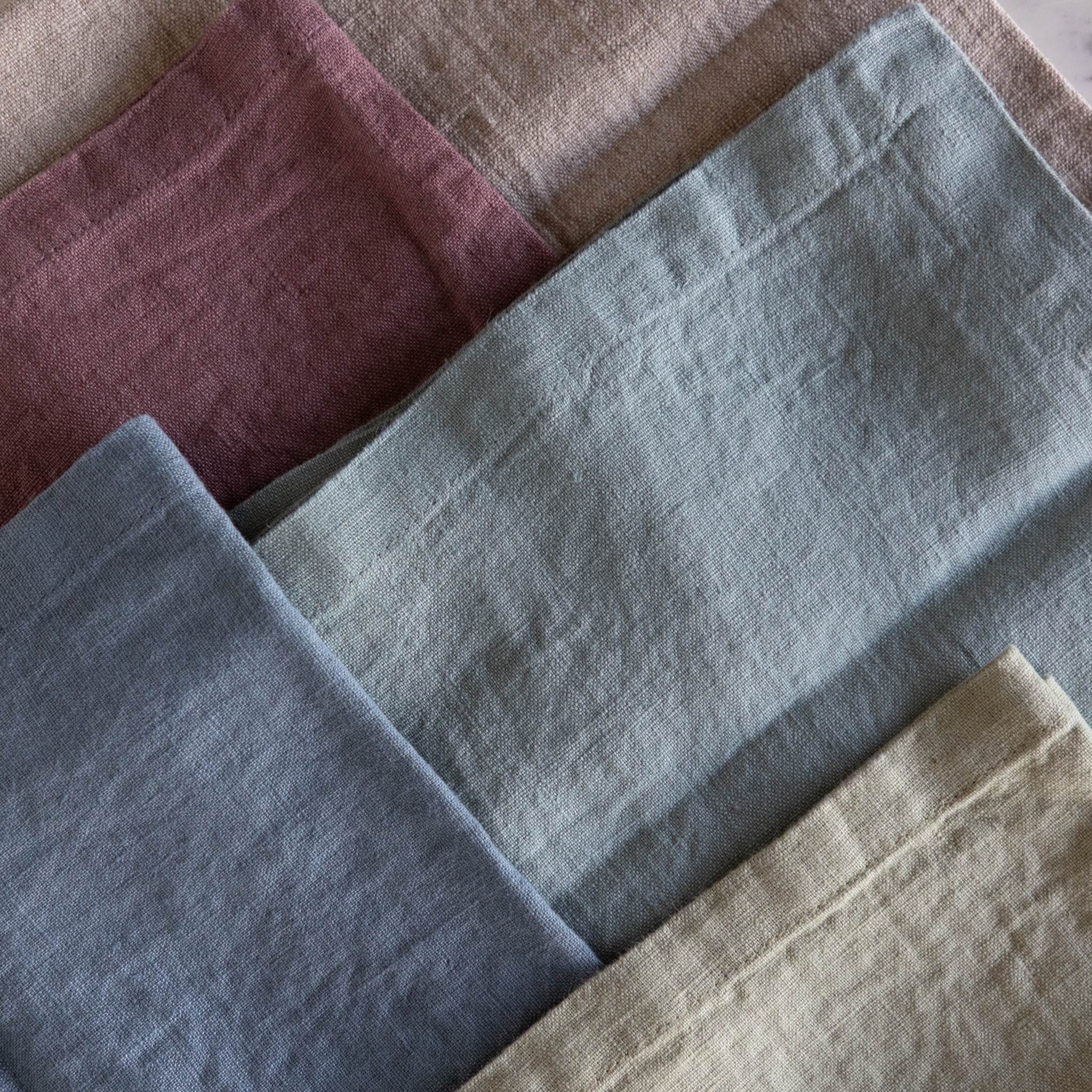 Folded fabric swatches in various colors including purple, blue, and beige.