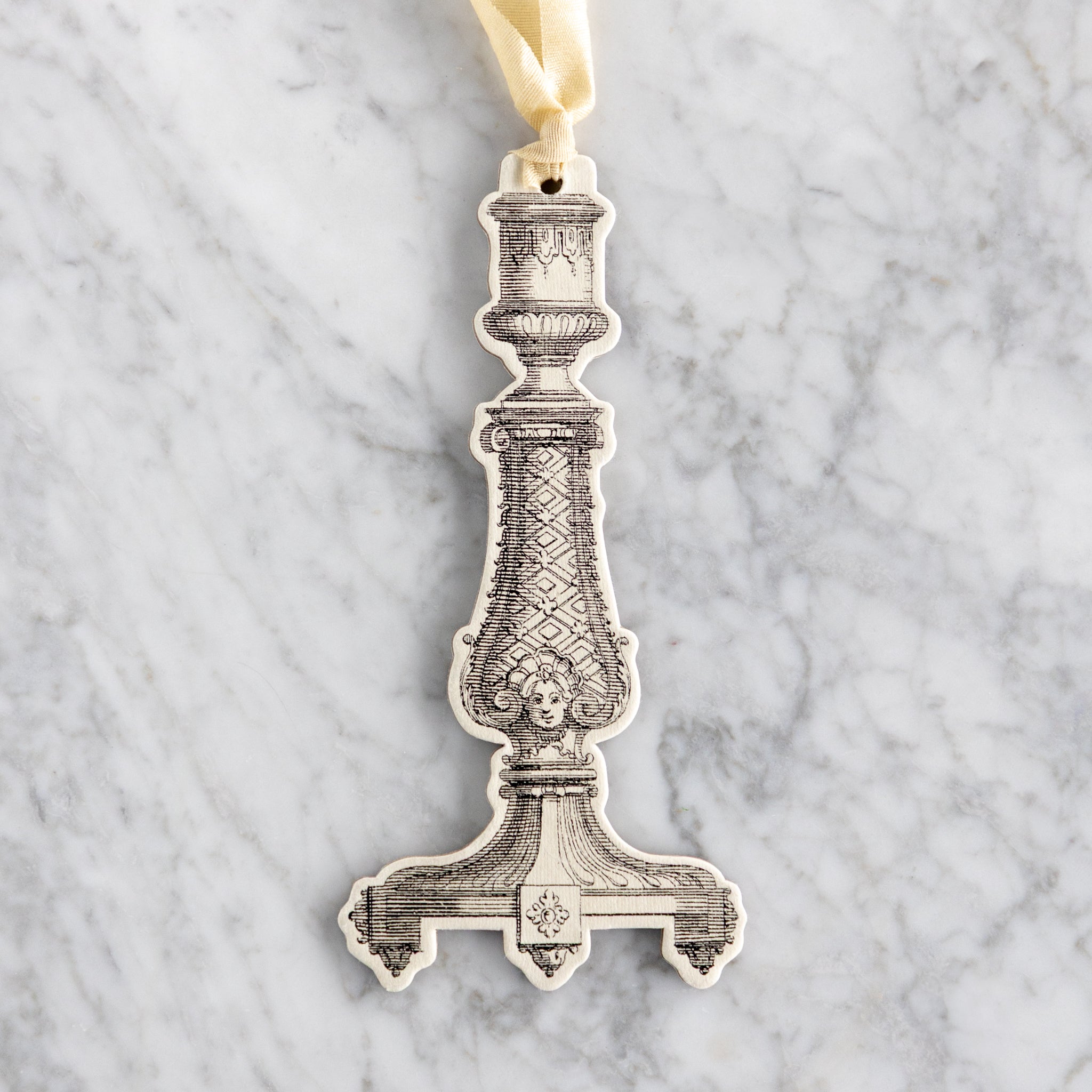 Decorative candlestick ornament on a marble background.