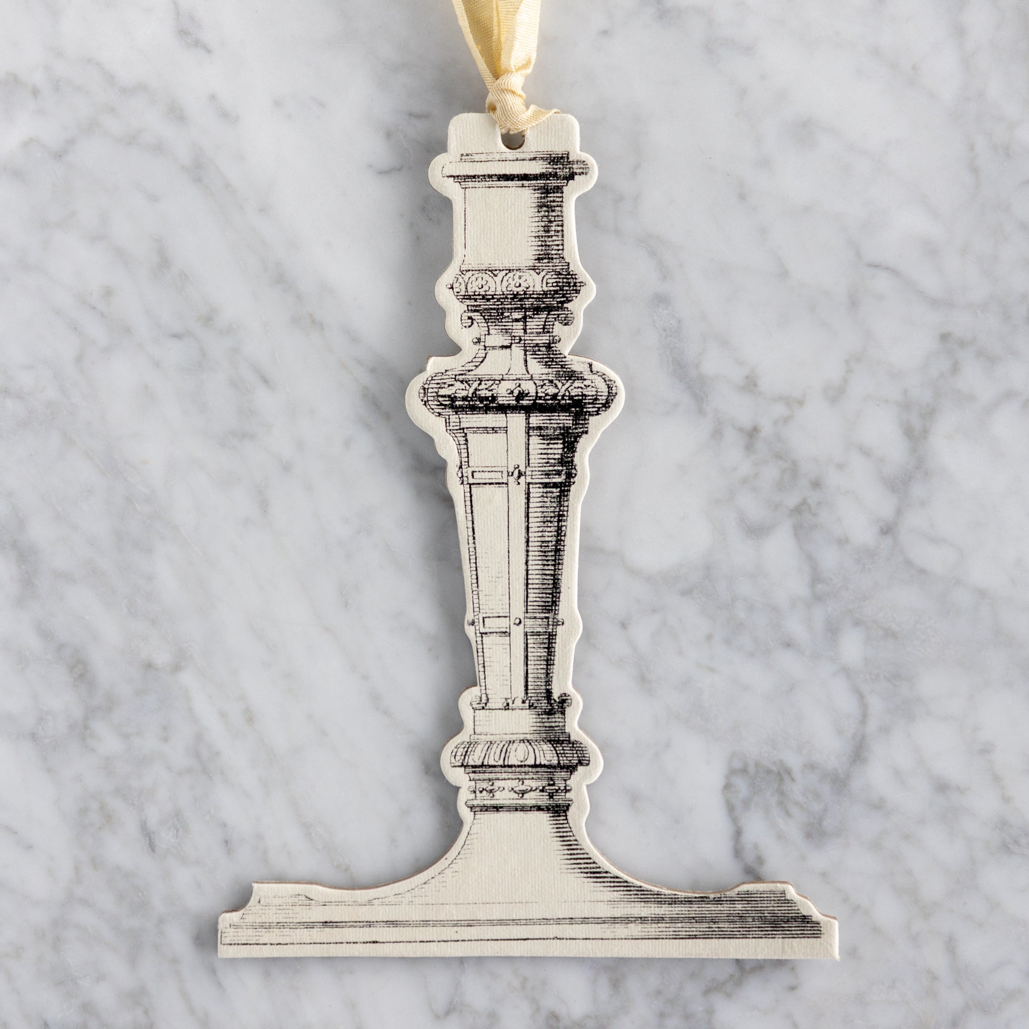 Decorative candlestick ornament on a marble background.