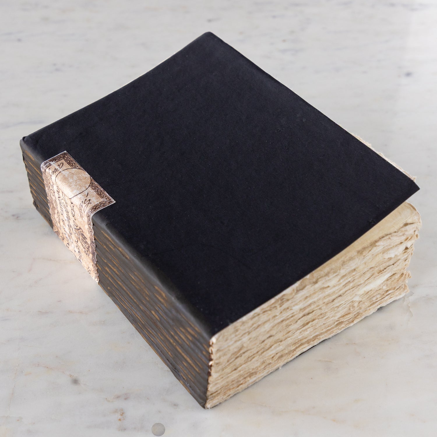 Large Handmade Paper Notebook with a blue cover and vintage torn paper edges on a marble table.