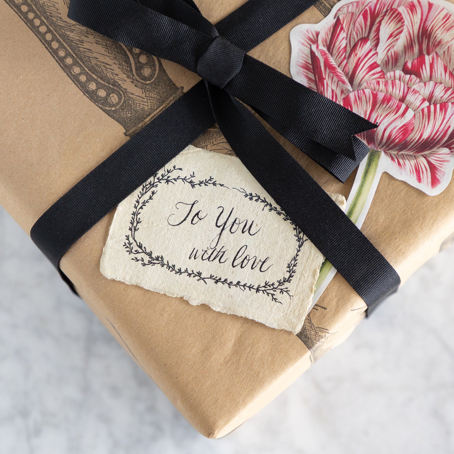 Gift wrapped in Cutlery on Kraft Runner tied with a black ribbon and &