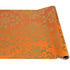 Roll of orange paper with gold floral pattern on a white background
