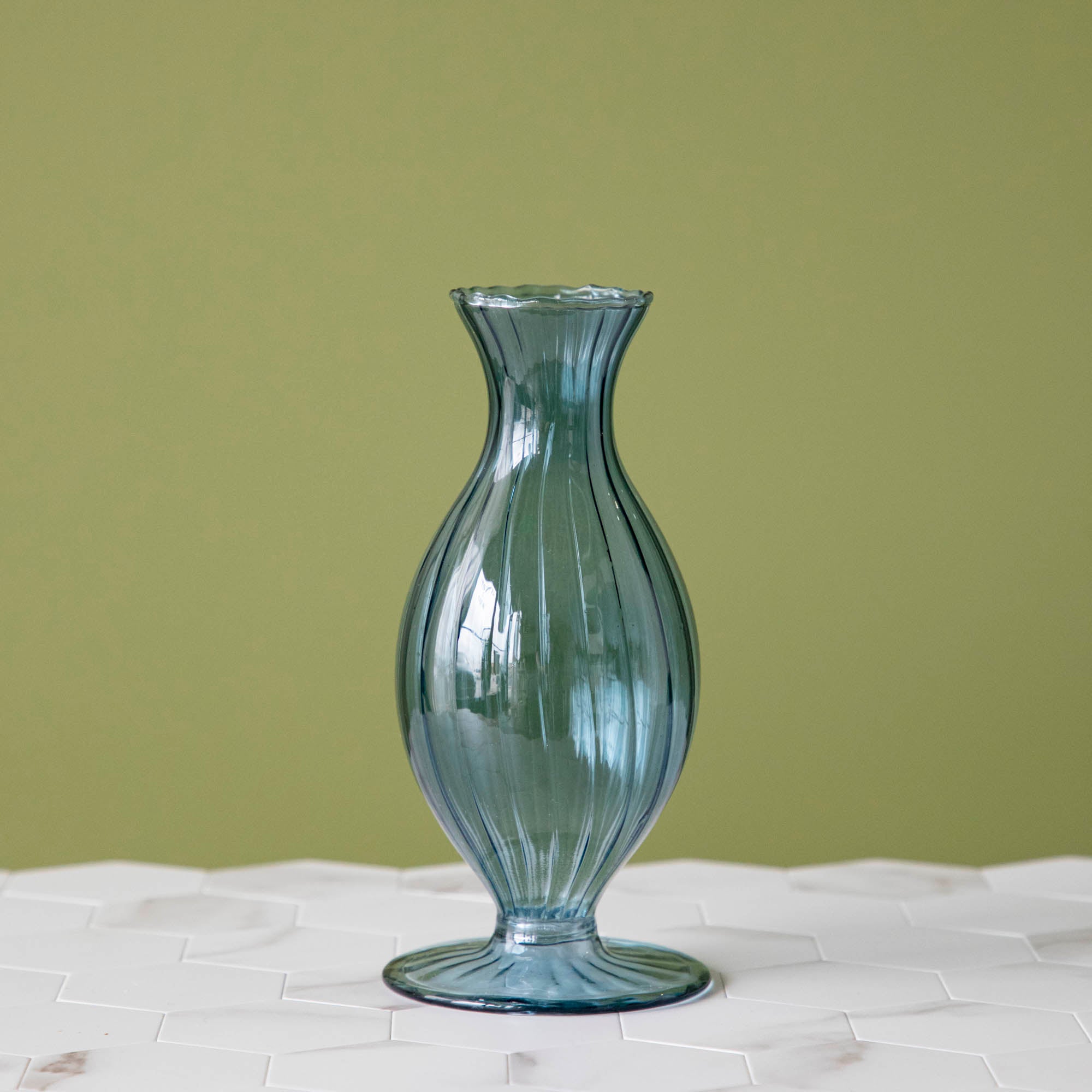 A Blue Vintage Boutique Vase by Accent Decor sitting on top of a table.