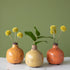 Three Yellow-Orange Glazed Stoneware Bud Vases with flowers in them, featuring a crackled finish by Park Hill.