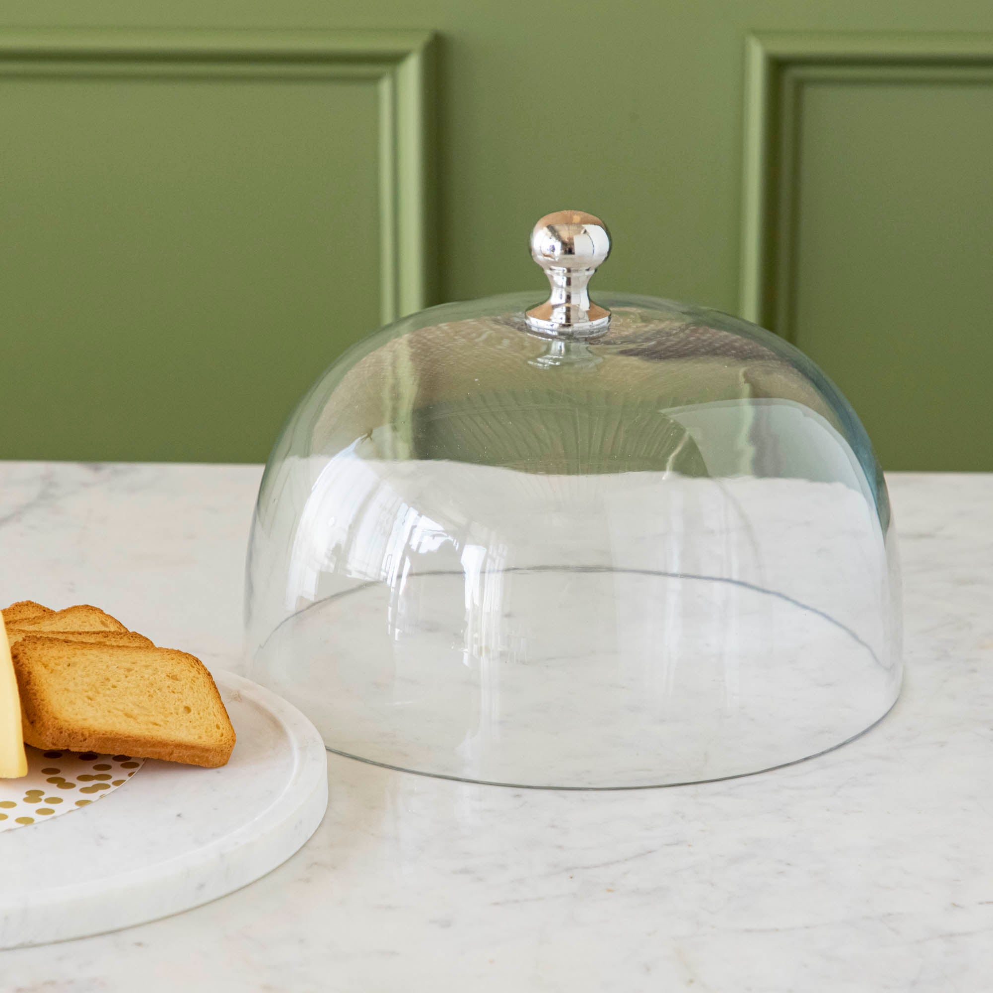 Chocolate muffins under a Bidk Home Marble &amp; Glass Food Dome with Knob, 11.5&quot; Diameter, presented on a white marble plate.