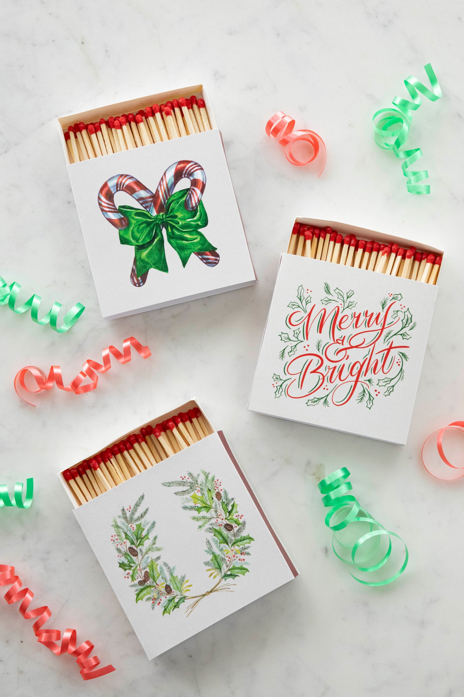 3 boxes of holiday themed matches laying on a marble background.