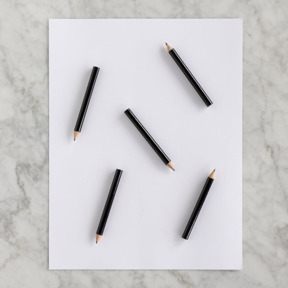 Five Mini Black Round Golf Pencils on a piece of paper. 