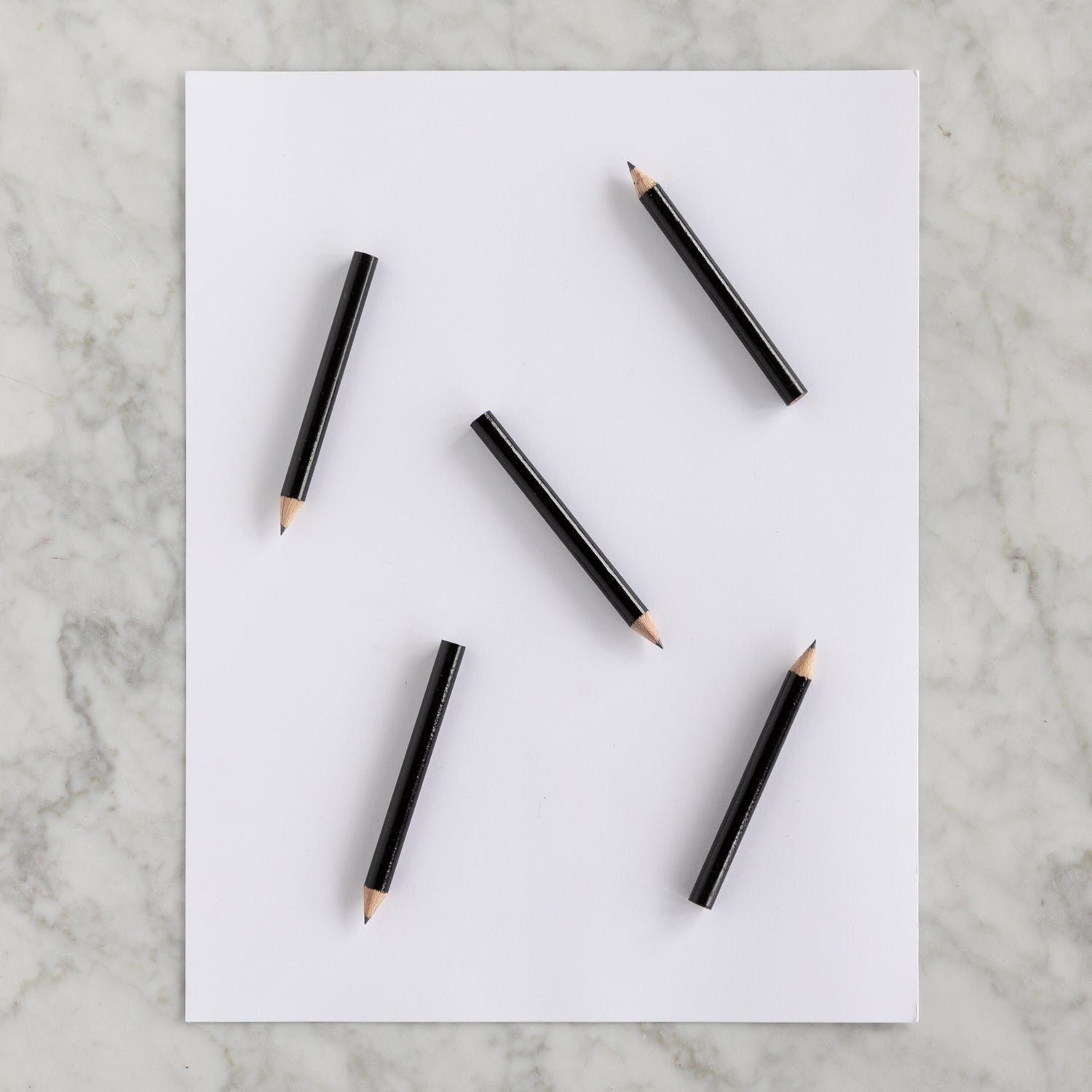 Five Mini Black Round Golf Pencils on a piece of paper. 