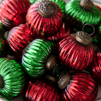 Close up of mini red and green ribbed ornaments bunched together.