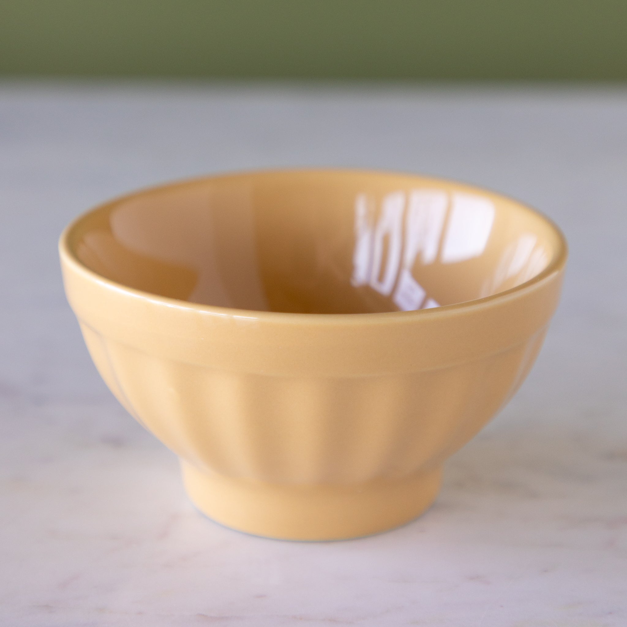 Toffee-colored ceramic ice cream bowl on a marble table.