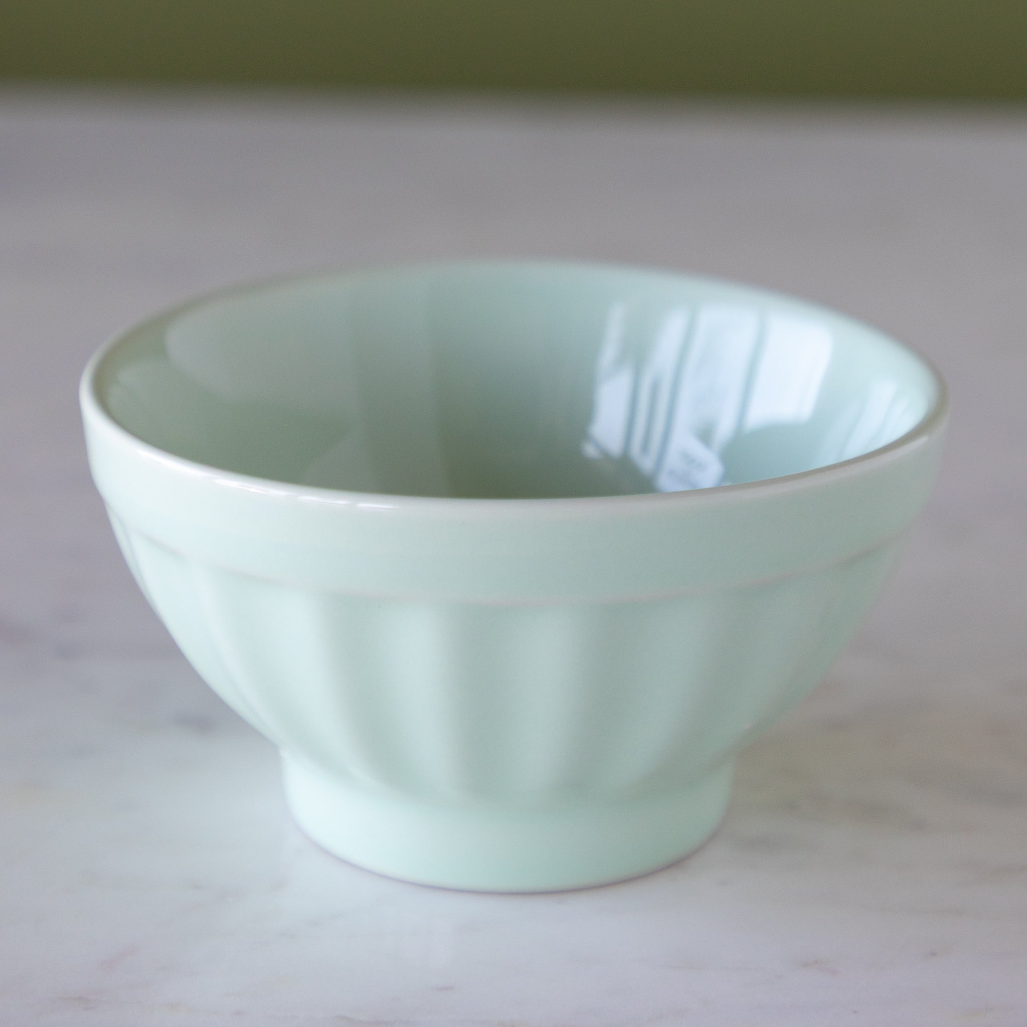Light blue ceramic ice cream bowl on a marble table.