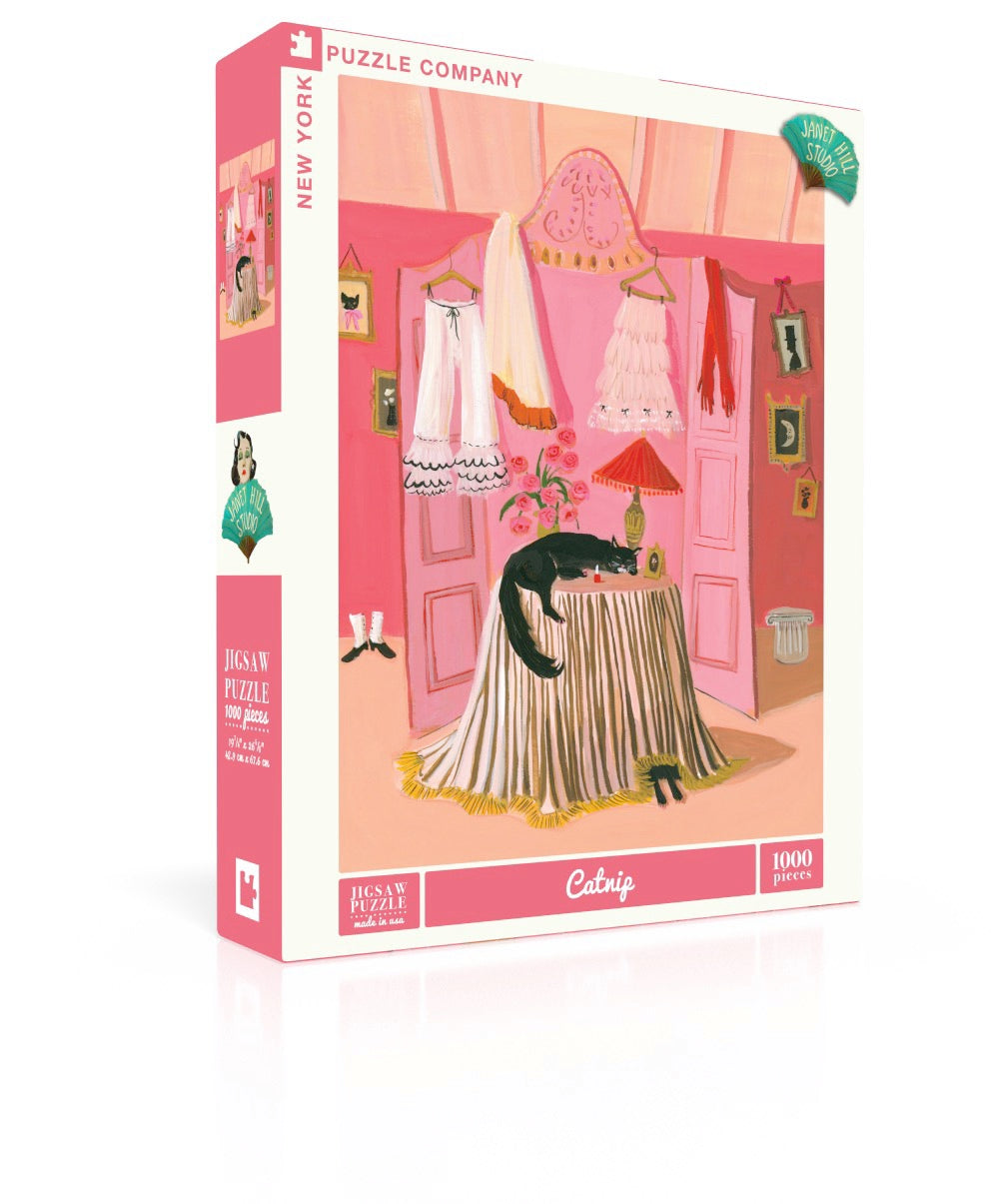 Puzzle box with artwork of a cat sleeping on a round table with a dressing screen behind it in pink with clothes strewn over it.  Artwork by Janet Hill.