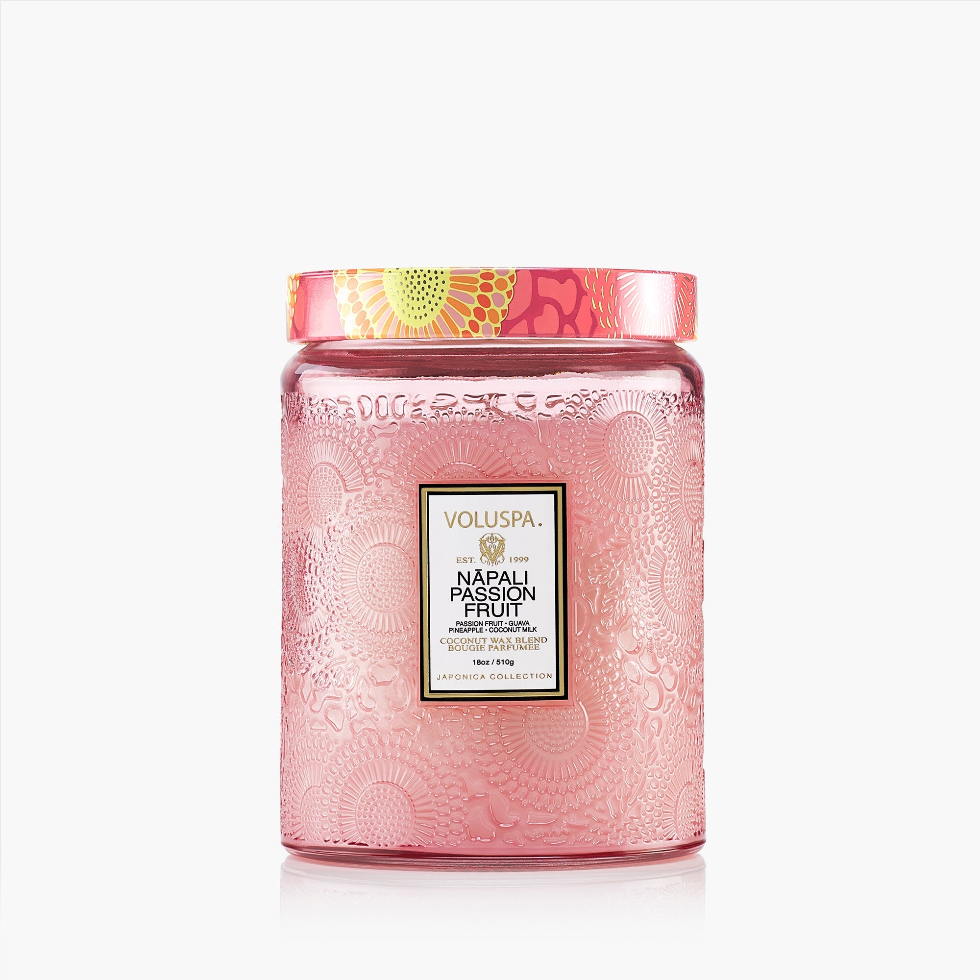 Pink candle jar with decorative lid and Voluspa branding on a white background